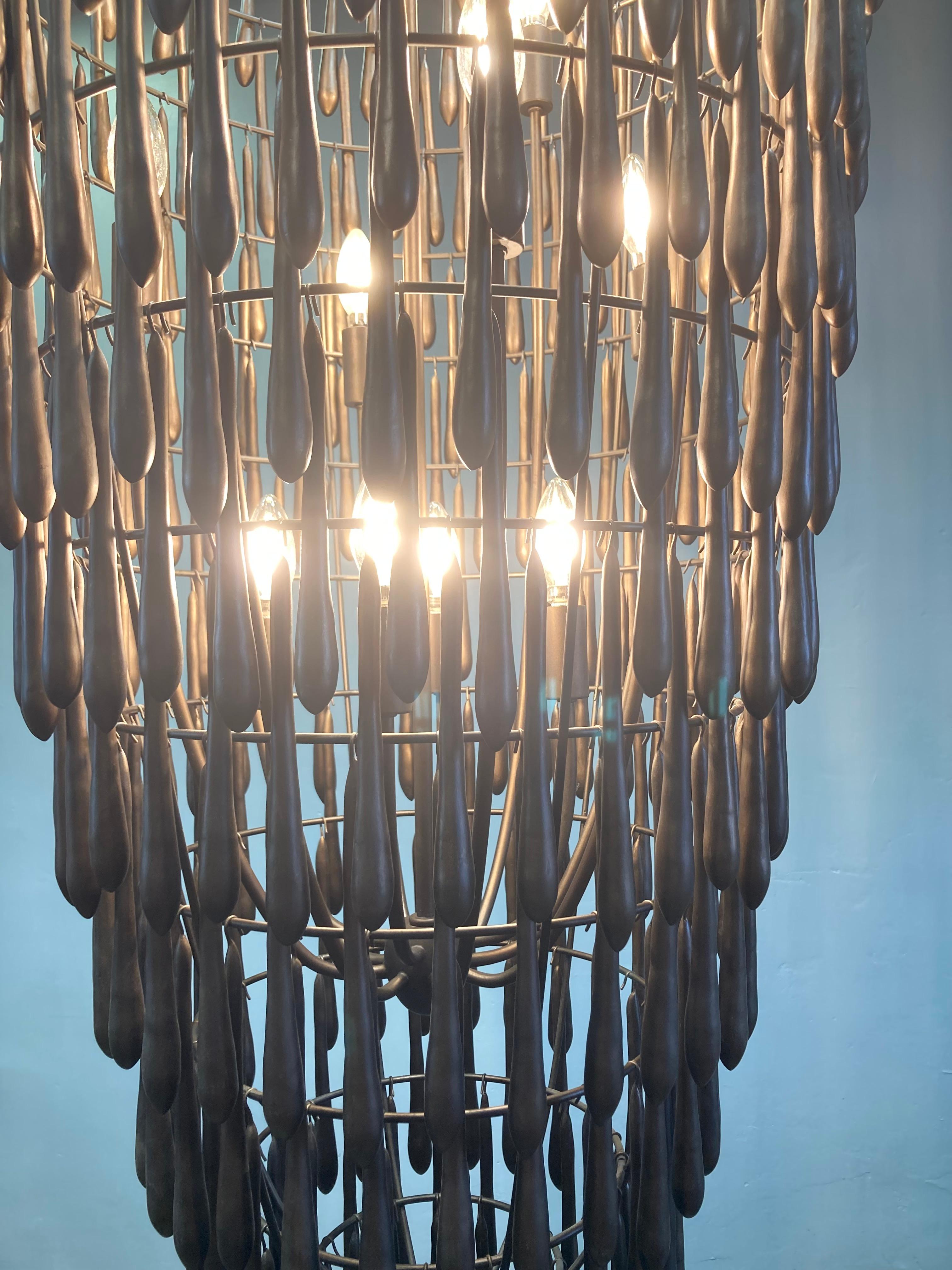 Spettacolare lampadario alto Visual Comfort Vacarro, con finitura a foglia di bronzo antico. Unico e grandioso, questo lampadario è molto grande e deve essere appeso in un luogo dal soffitto alto. Realizzato con una struttura in acciaio con