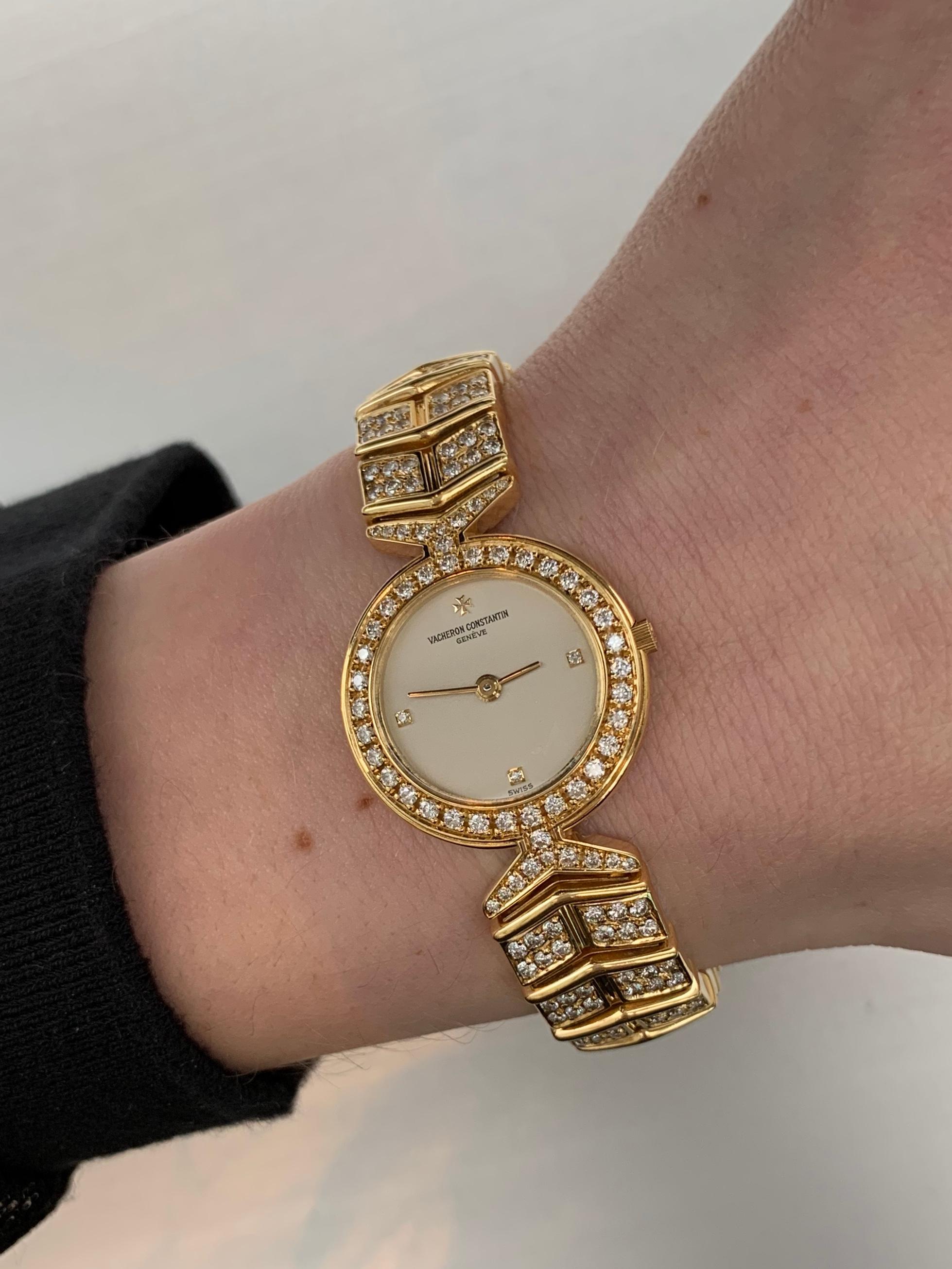 An 18k yellow gold Vacheron Constantin Malta watch with diamond bezel and diamond bracelet. Timepiece has a cream color diamond with three diamond hour marks. Case measures 22mm and bracelet has a width of 11.50mm, fixed with a butterfly deployment