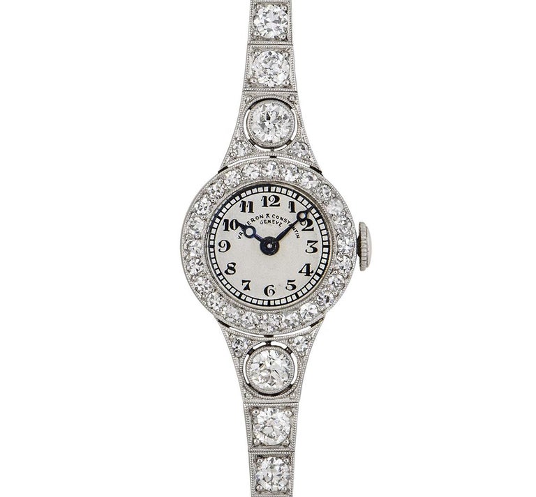 A 15 mm Platinum Vintage Ladies Cocktail Dress Wristwatch from the 1920s, silver dial with arabic numerals, blued steel hands, a fixed platinum bezel set with 24 round brilliant cut diamonds (~0.33ct), platinum shoulders each set with 3 round