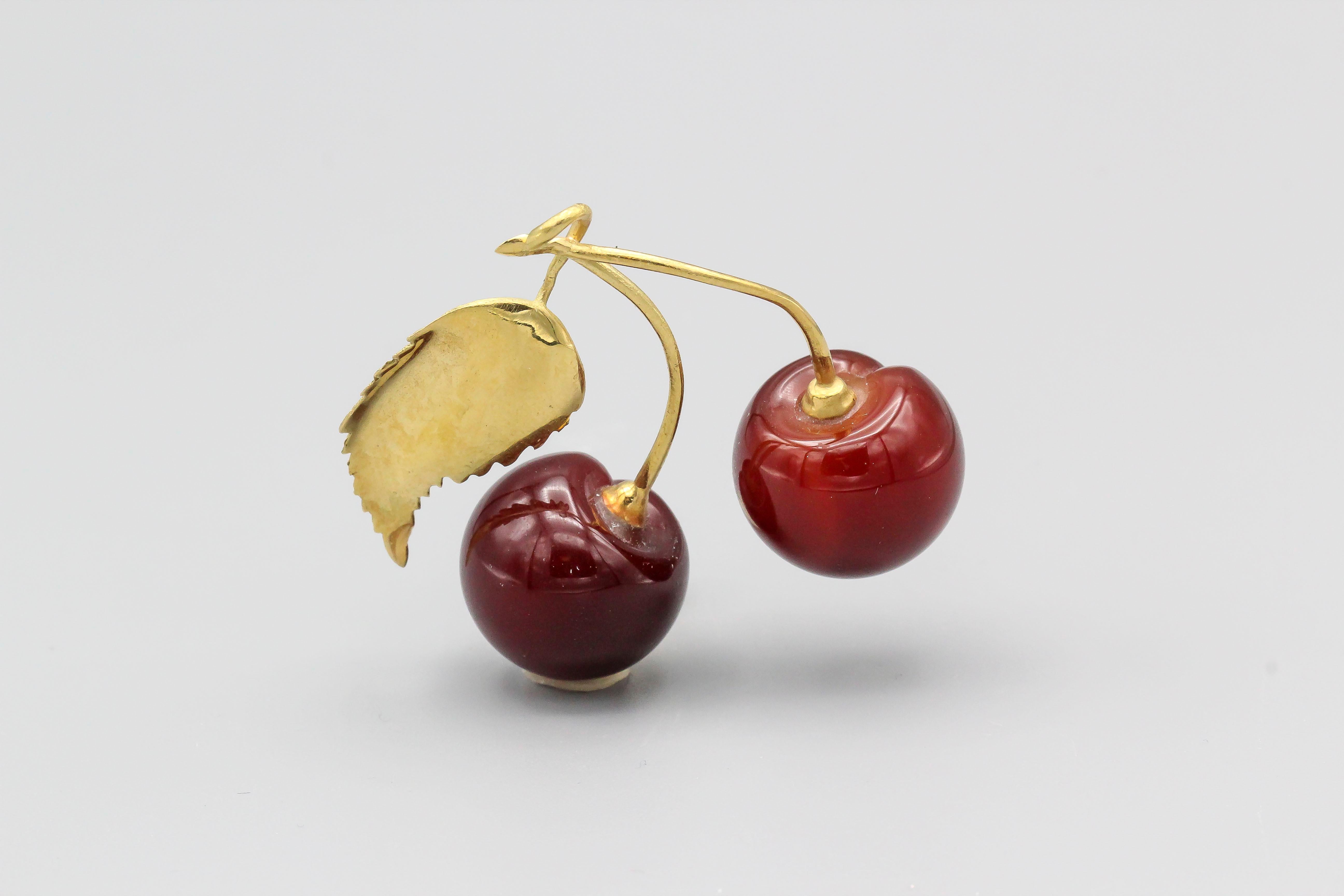 Fine carved carnelian and 18k yellow gold cherries by Vacheron Constantin. It resembles the actual fruit quite accurately, with gold as the top leaf and stem.

Hallmarks: Vacheron Constantin maker's mark, 750.