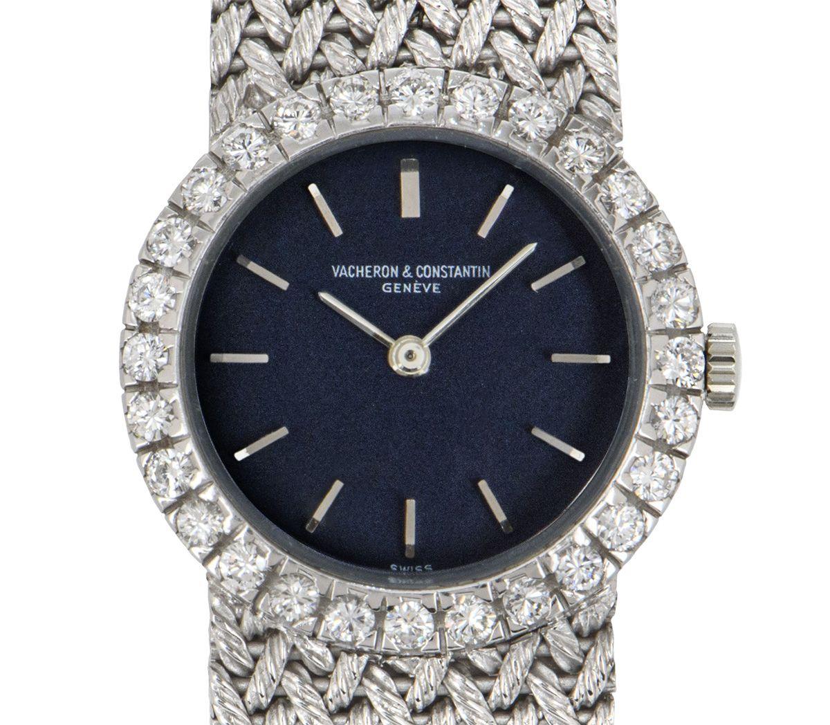 A 23 mm vintage white gold cocktail dress watch by Vacheron Constantin, featuring a blue dial with applied hour markers. The bezel is adorned with 28 round brilliant cut diamonds. Bringing the white gold integrated bracelet together is a concealed