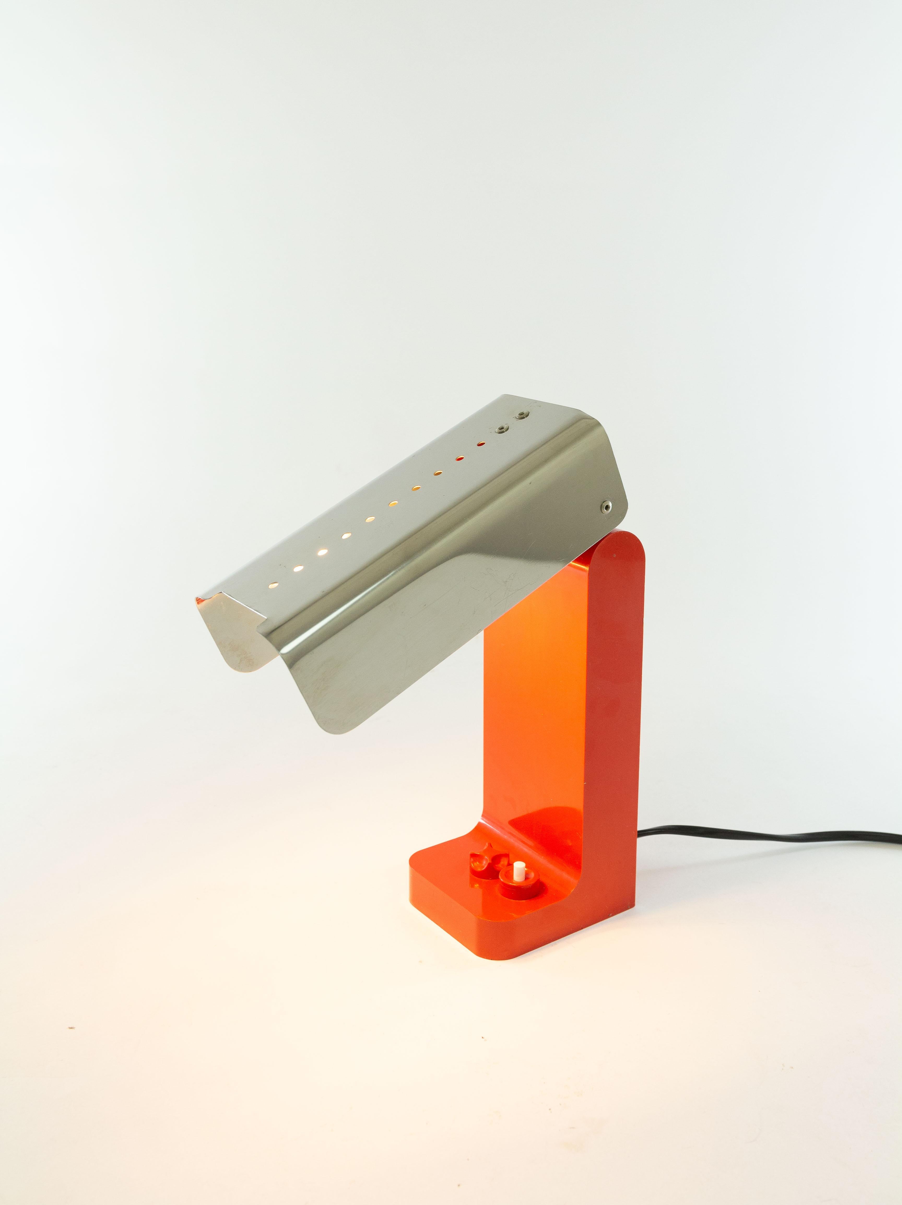 Red Vademecum (model 4034) table lamp designed by Joe Colombo in 1968 and manufactured by Kartell.

The Vademecum lamp is made of a plastic base and a stainless steel arm or shade. This part is adjustable and can even be completely folded. The
