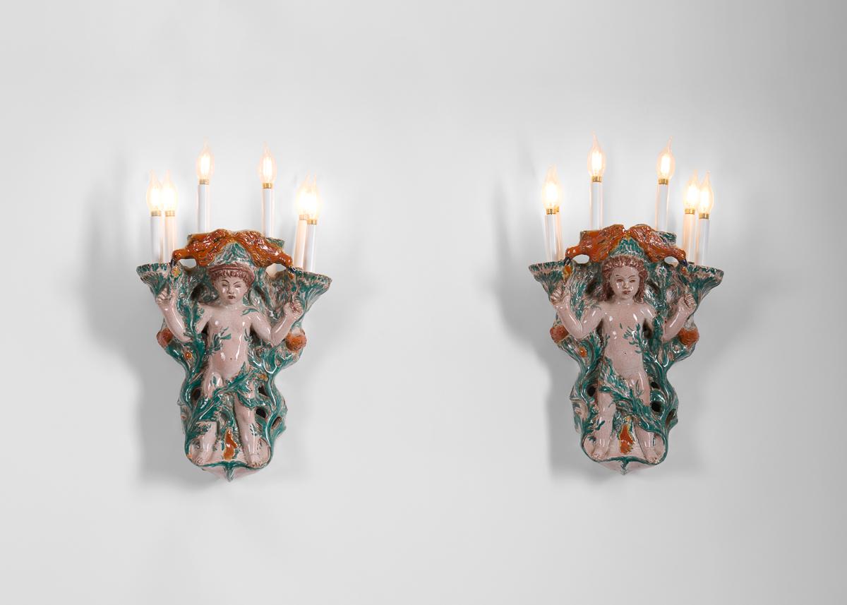 This pair of glazed earthenware sconces is a marvelous example of the work of the unique Russian-born sculptor and designer Vadim Androusov, who studied in France as Art Deco reached its maturity, and whose subjects were frequently classical in