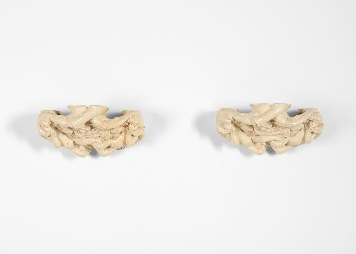 This pair of glazed earthenware sconces is a marvelous example of the work of the unique Russian-born sculptor and designer Vadim Androusov, who studied in France as Art Deco reached its maturity, and whose subjects were frequently classical in