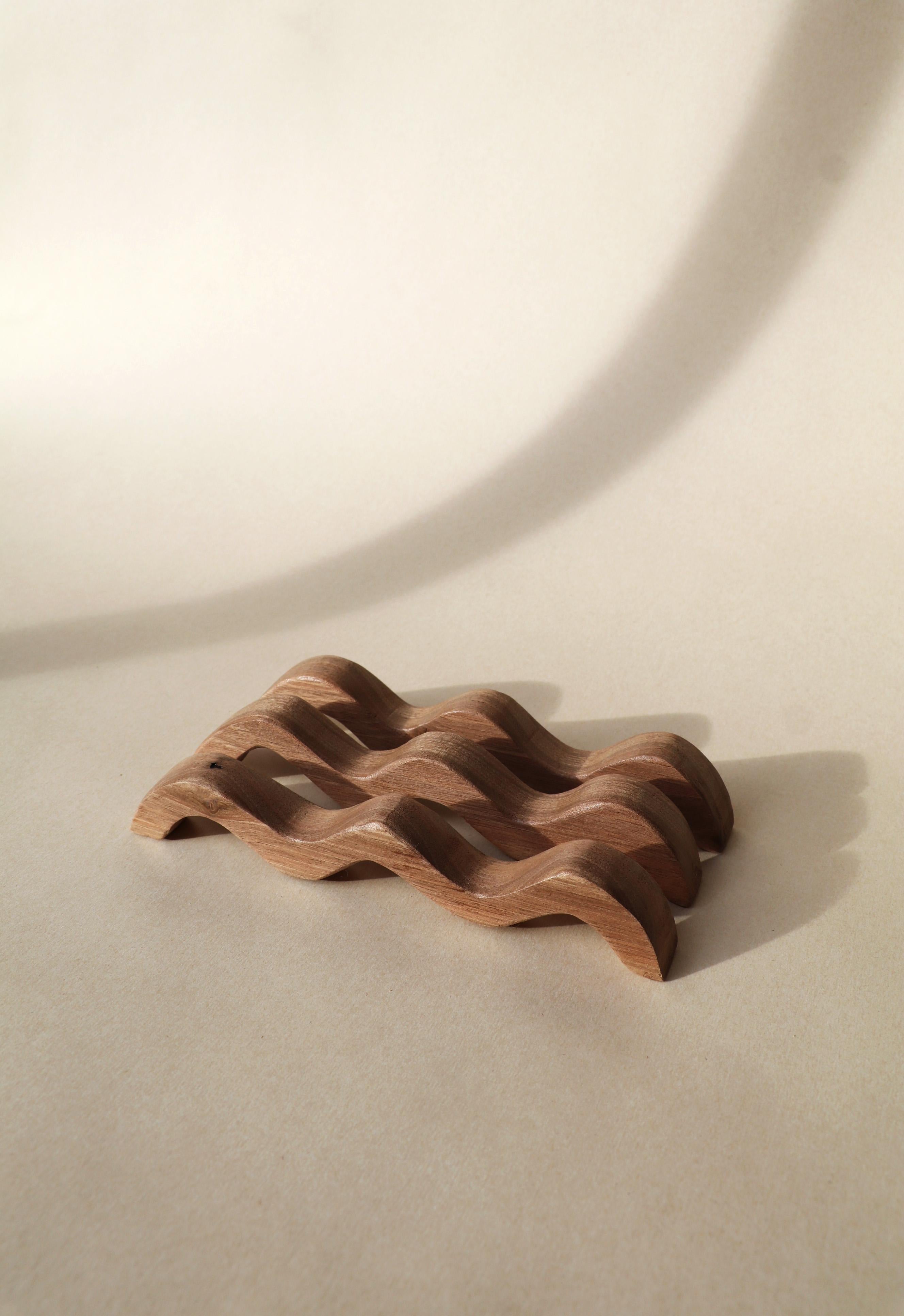 Vagues Wood Trivet by Alice Lahana Studio
Dimensions: W 20.5 x D 3 x H 4 cm (dimensions may vary)
Materials: Walnut

Handcrafted in walnut, the Waves trivet is made up of three individual and modular elements. It thus offers an infinity of