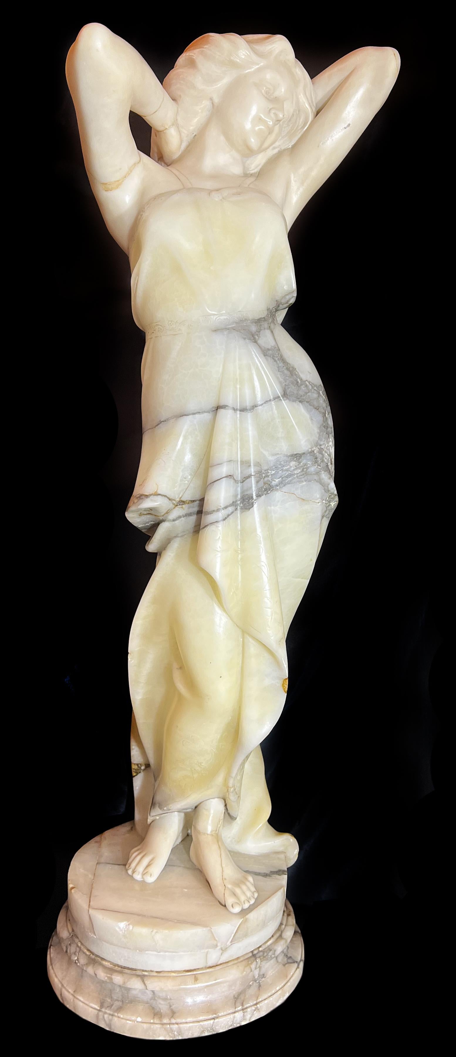 Sculpture raffinée représentant une femme affichant sa beauté. Notez comment le veinage du marbre simule la robe.