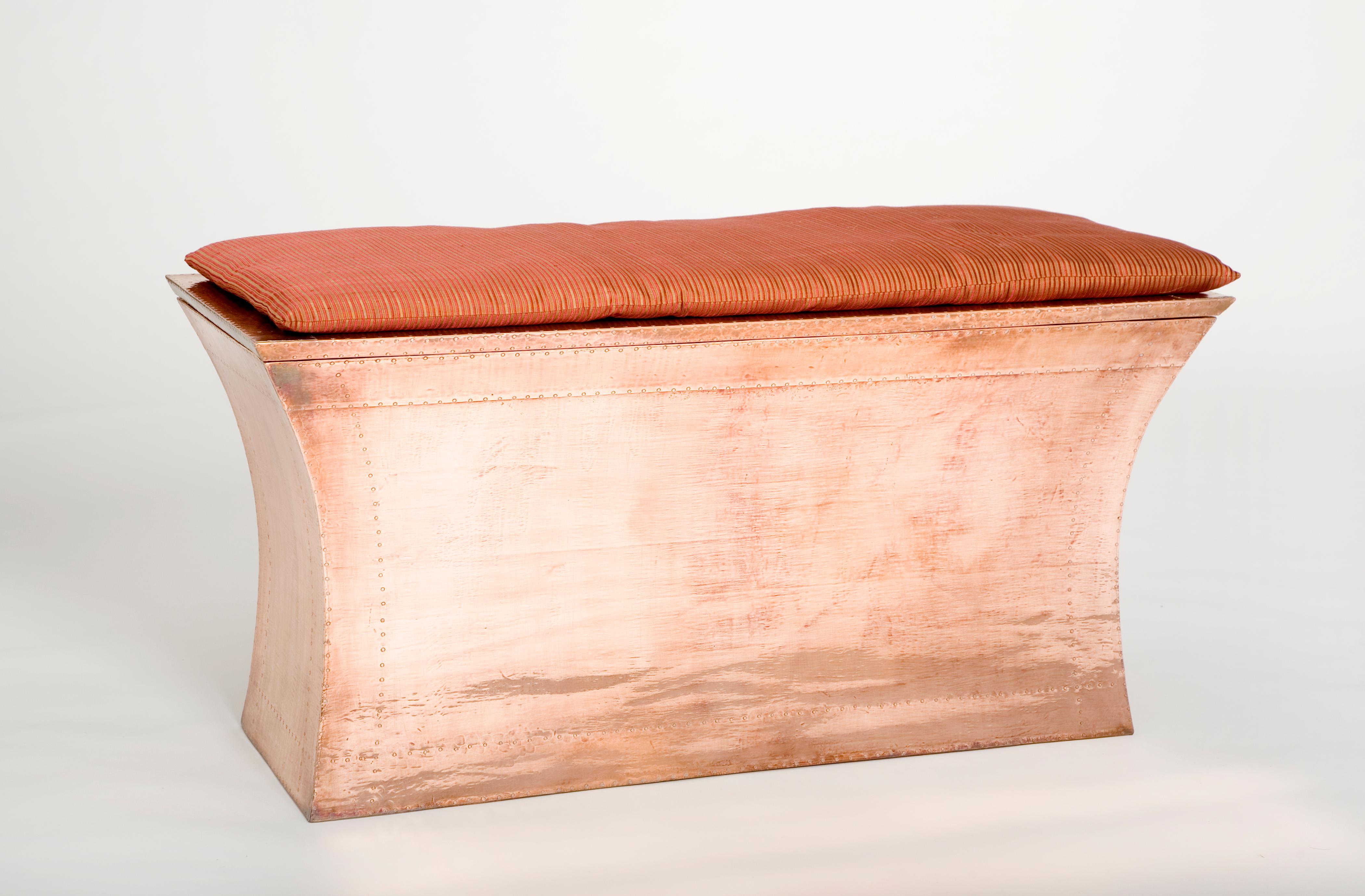 The traditional metal clad furniture he found in India inspired renowned designer Paul Mathieu to create this elegant and curvaceous storage bench.
 
The arcing sides and top of this piece are hand carved from solid pieces of teak. The hinged lid