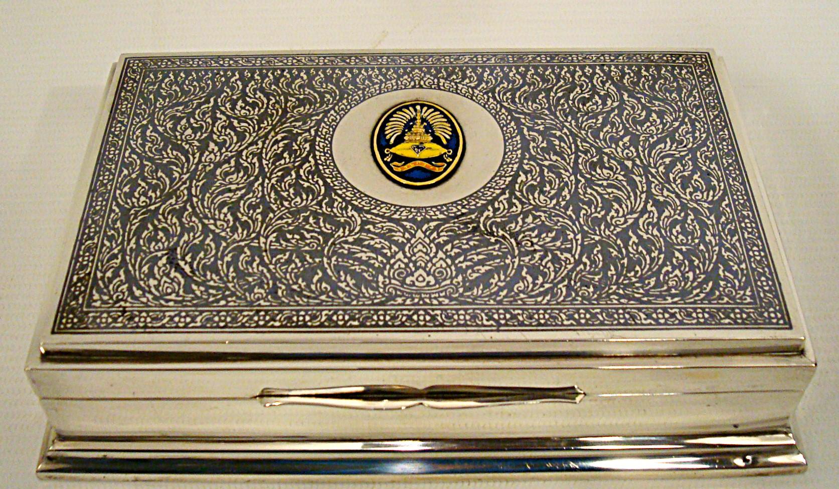 Thailandia Smalto - Oro - Argento Raro Scatola per gioielli.
Scatola decorativa Vintage del 1990

Eleganza della scatola da scrivania in smalto, oro e argento. Viene fornito con una scheda personale originale di chi era il principe, ora il re. Dice: