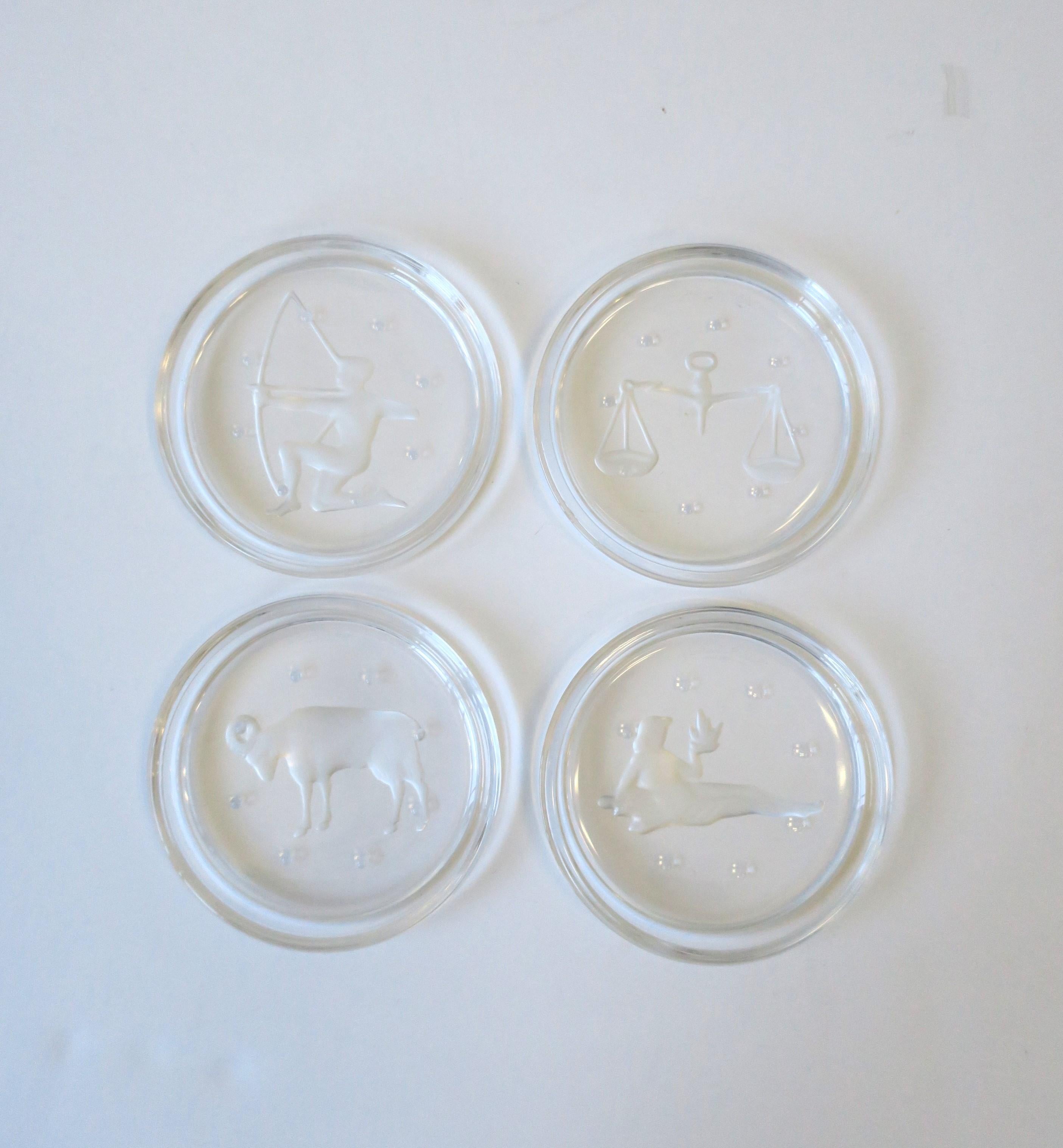 A set four (4) etched Belgian coasters depicting signs of the zodiac and other from luxury crystal Maison Val Saint Lambert, circa late-20th century, Belgium. Essential for protecting furniture tops. With maker's acid mark on bottom as shown in last