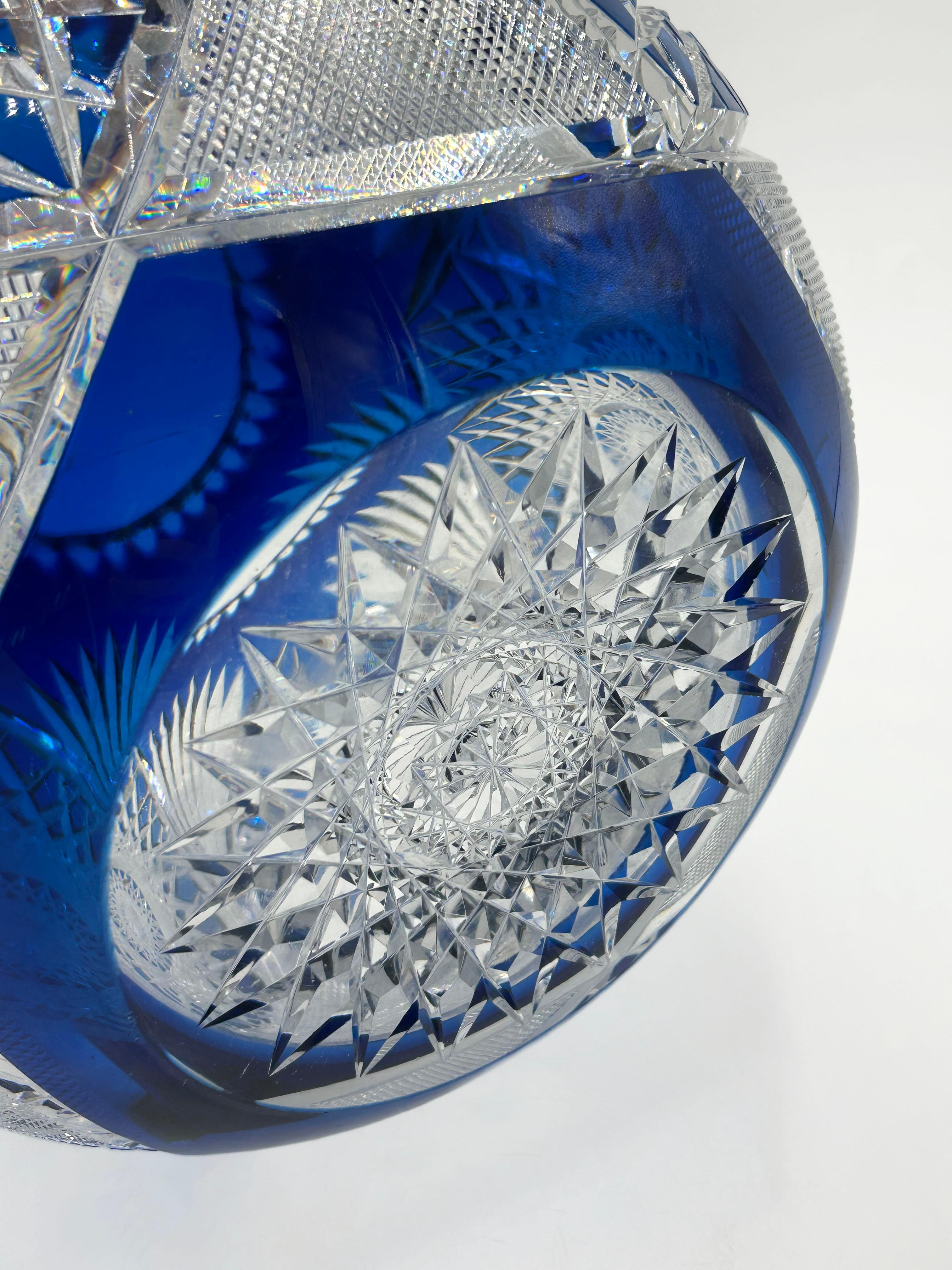 Val Saint Lambert Cut Crystal Ball in Cobalt Blue
Val Saint Lambert cut crystal ball in cobalt blue. Its rounded shape features an intricately carved surface with a geometric pattern that alternates between blue and clear crystal. The design