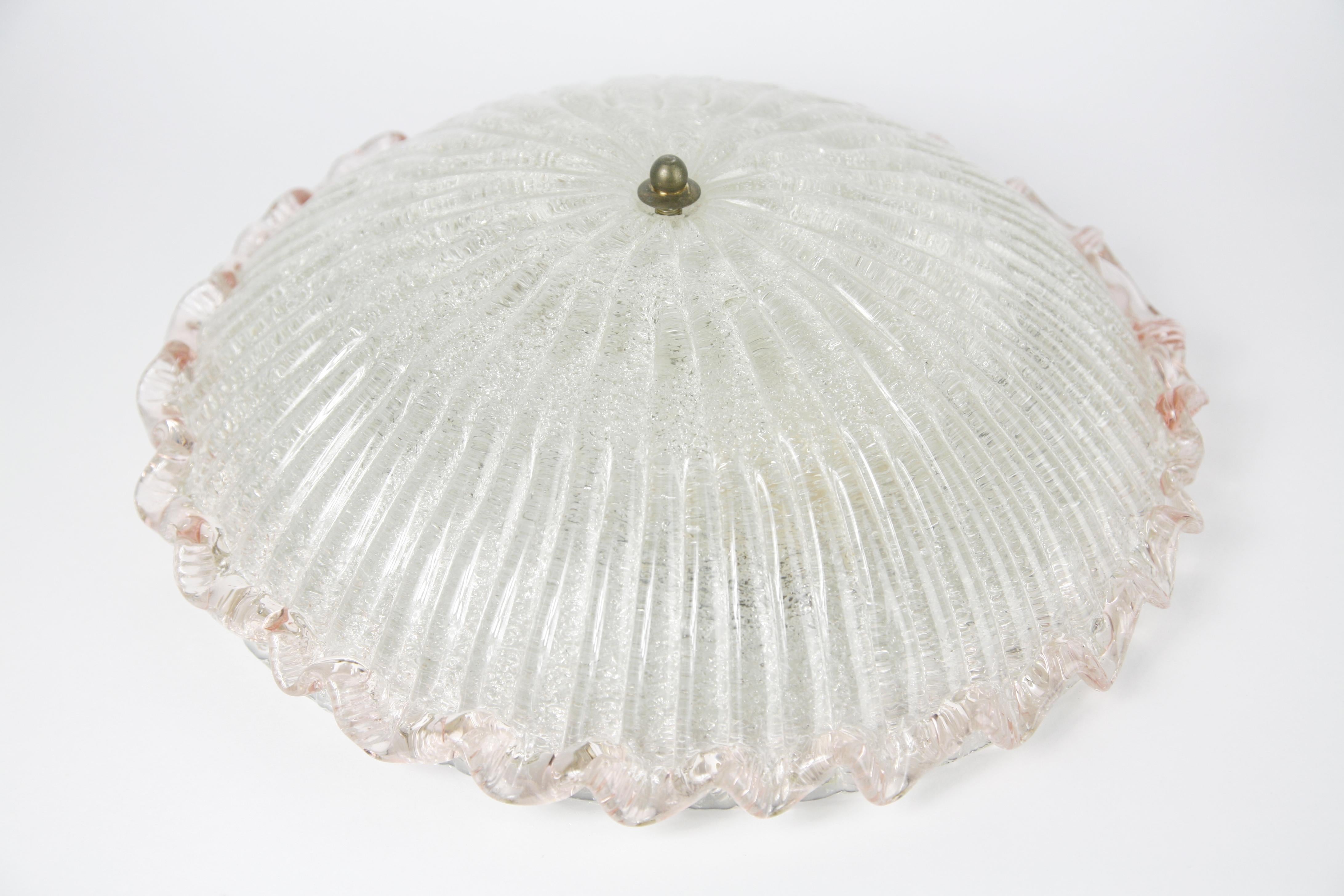 1950s Val Saint Lambert flush mount ceiling plate is white metal with 2 European sockets the shade is a dome shaped pressed glass that is clear with glass flakes on the inside of the dome which gives an effect in the glass the outer edge is pink