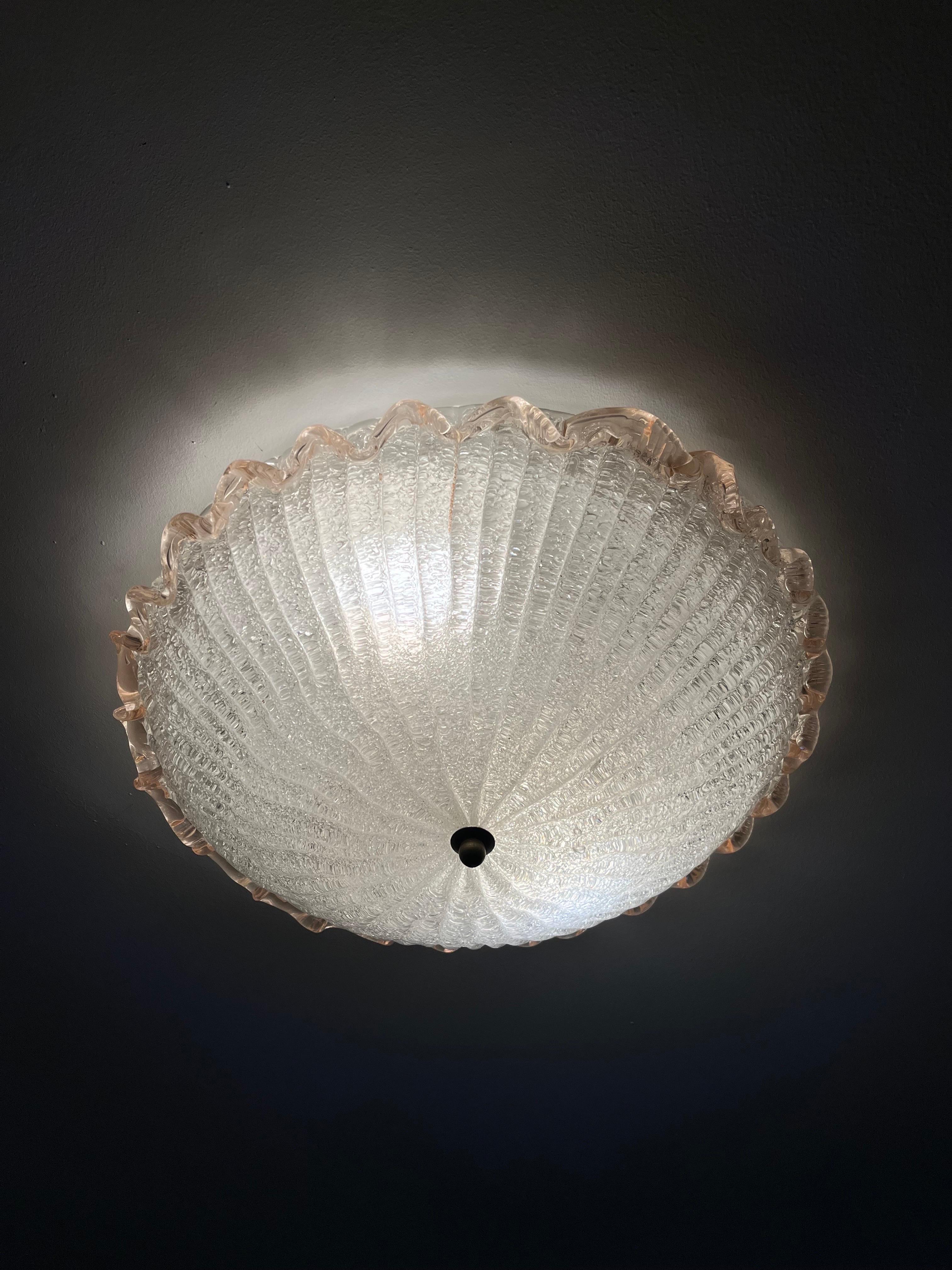 1950s Val Saint Lambert flush mount ceiling plate is white metal with 2 Edison sockets the shade is a dome shaped glass with glass flakes on the inside of the dome which gives an effect in the glass the outer rim is pink wavy glass and details in