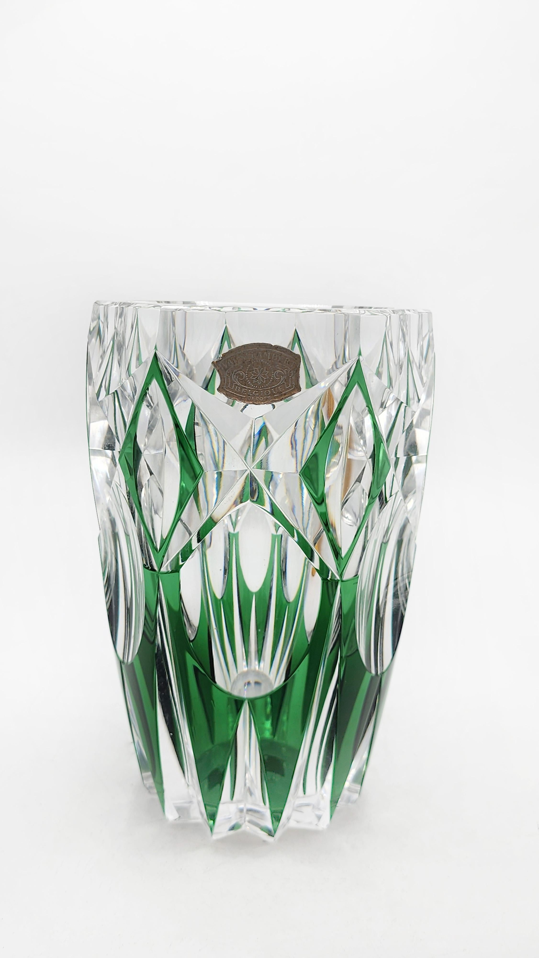 Val Saint Lambert green cut crystal vase.
Green cut crystal vase. It features a cylindrical shape that widens slightly toward the top. The design features deep carving that creates a pattern of diamonds and vertical lines, highlighting the green