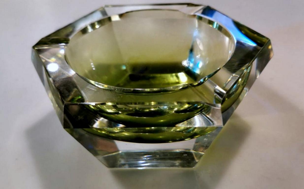Massive ashtray in pure lead oxide crystal; it has beautiful shades of green; its hexagonal shape and the way the crystal has been cut, contribute to creating particular and involving plays of light; it was made between 1962 and 1965 and bears the