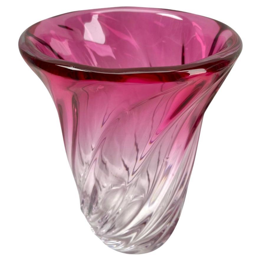 Val Saint Lambert,  sculpted crystal vase with amethyst core, Belgium.

Heavy Val Saint Lambert crystal vase catalogued in the 1950s.
The central amethyst color (a traditional favorite for VSL) has been given a thick Sommerso (clear layer on the