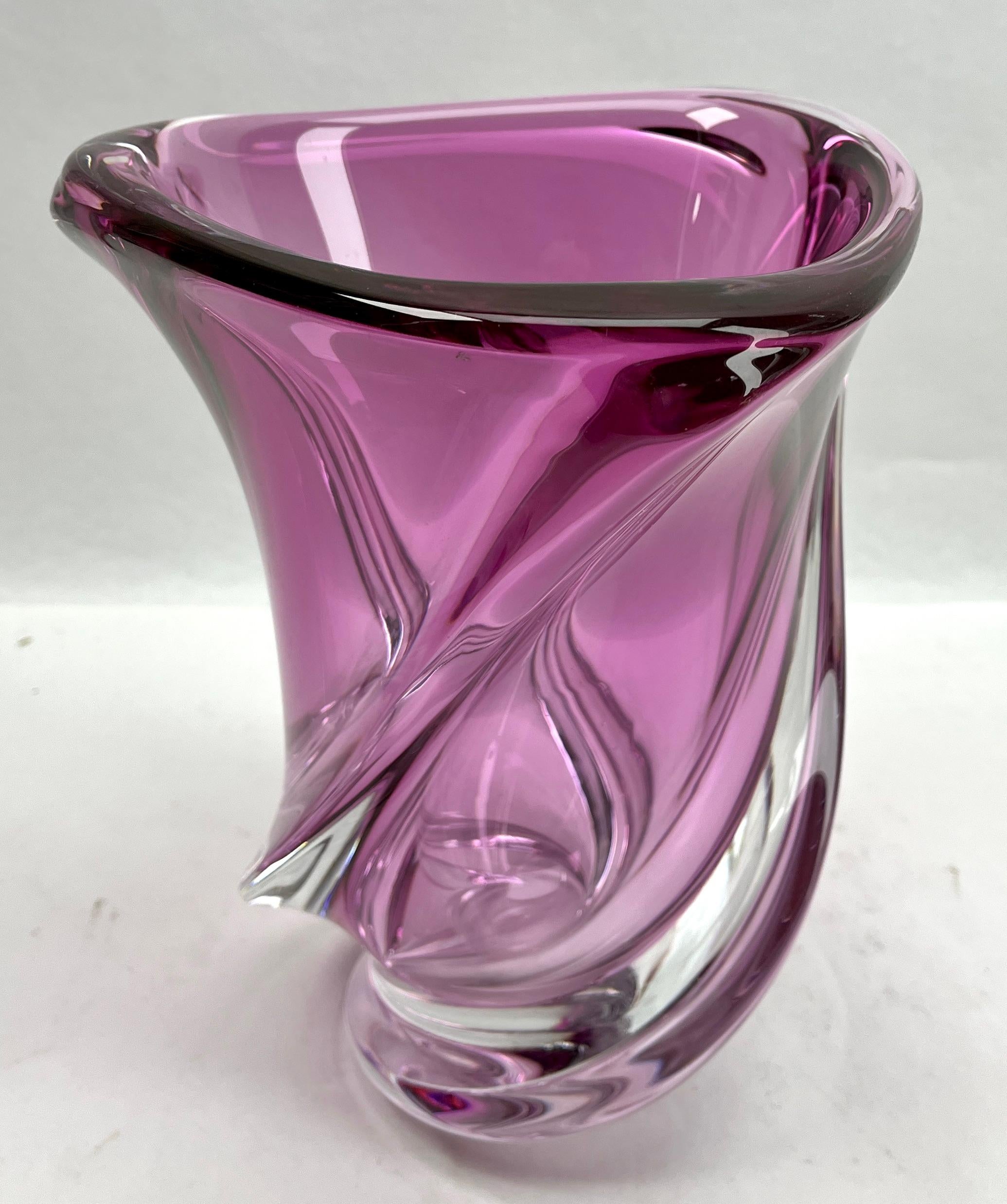 Val Saint Lambert, sculpted crystal vase with amethyst core, Belgium.

Heavy Val Saint Lambert crystal vase catalogued in the 1950s.
The central amethyst color (a traditional favorite for VSL) has been given a thick Sommerso (clear layer on the