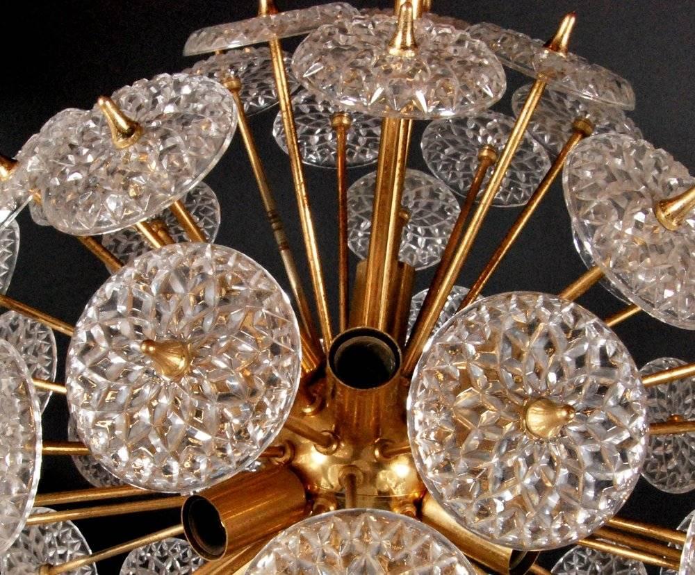 Eye-catching Sputnik chandelier in the style of Emil Stejnar. Manufactured in Belgium, circa 1970. This stunning piece has a high quality brass base with crystal glass flowers on the ends of many arms. The glass pieces are beautifully cut with a