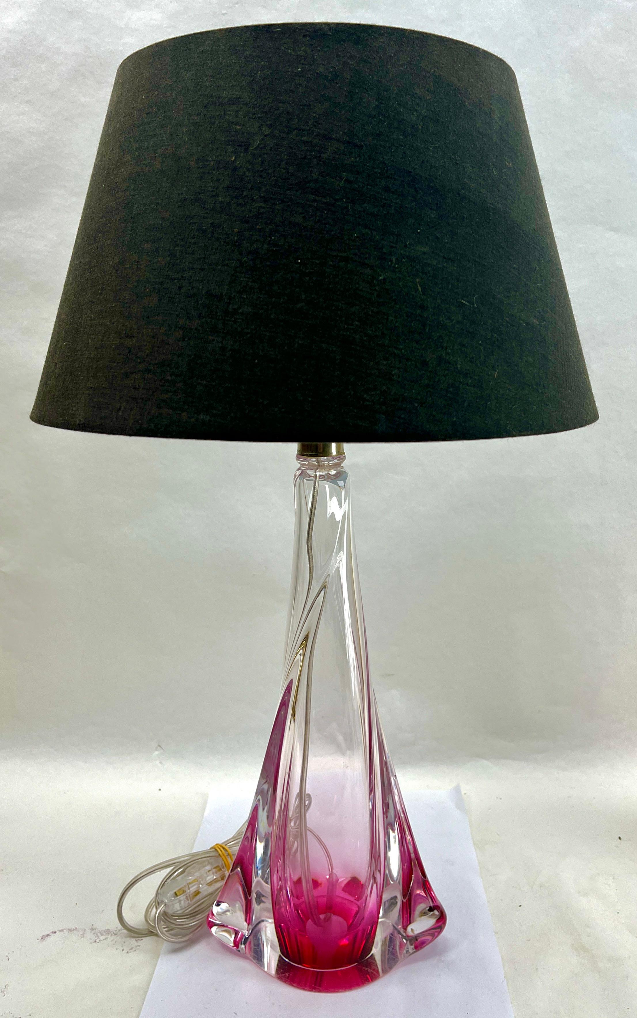 Cette lampe de table simple et gracieuse a une taille de 39 cm sans l'abat-jour.
Le noyau coloré, dans la teinte classique du Val Saint Lambert, a été doté d'un épais Sommerso (enveloppe de cristal clair) afin que l'objet paraisse délicat tout en