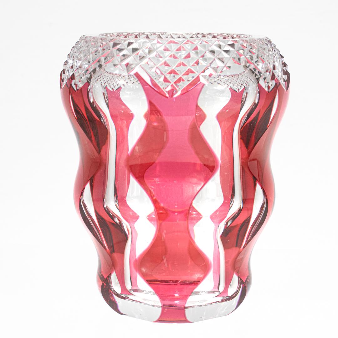 A fine Art Deco style cut-to-clear glass vase.

By Val St. Lambert.

With a red or cranberry cased curved body with cut-to-clear hourglass shaped panels and a strawberry field faceted cut top.

Many of these early designs were conceived by Joseph