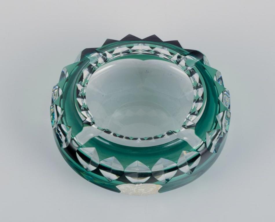 Val St. Lambert, Belgium. Faceted cigar ashtray in green and clear glass.
Mid-20th century.
With label.
In good condition with a few minor chips.
Dimensions: D 15.0 cm x H 5.0 cm.