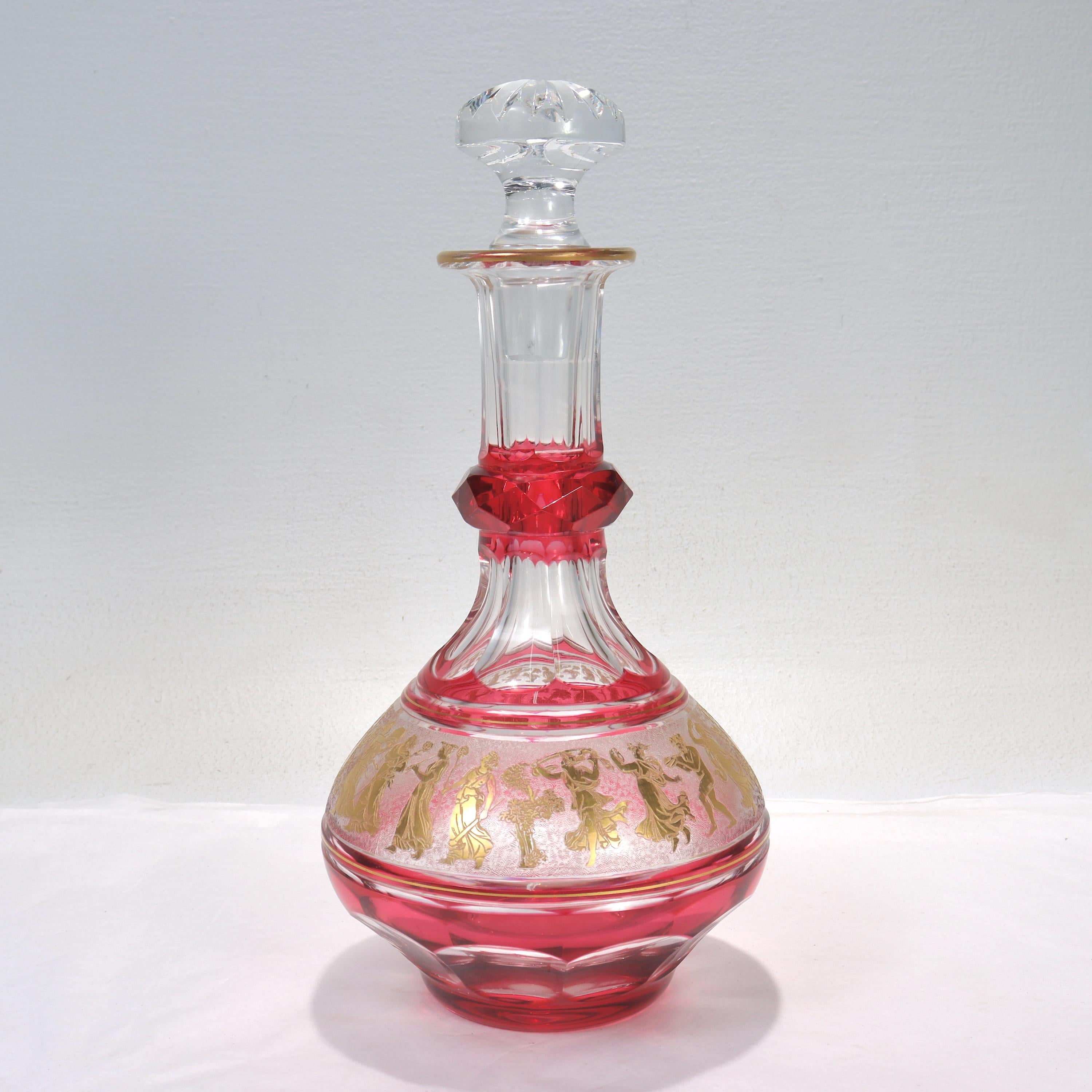 A very fine cranberry cut-to-clear glass or crystal wine decanter.

By Val St. Lambert.

In the Danse de Flore pattern. 

Encased in cranberry cut to clear glass with a gilt, acid-etched frieze of Bacchanalian dancers along the circumference.