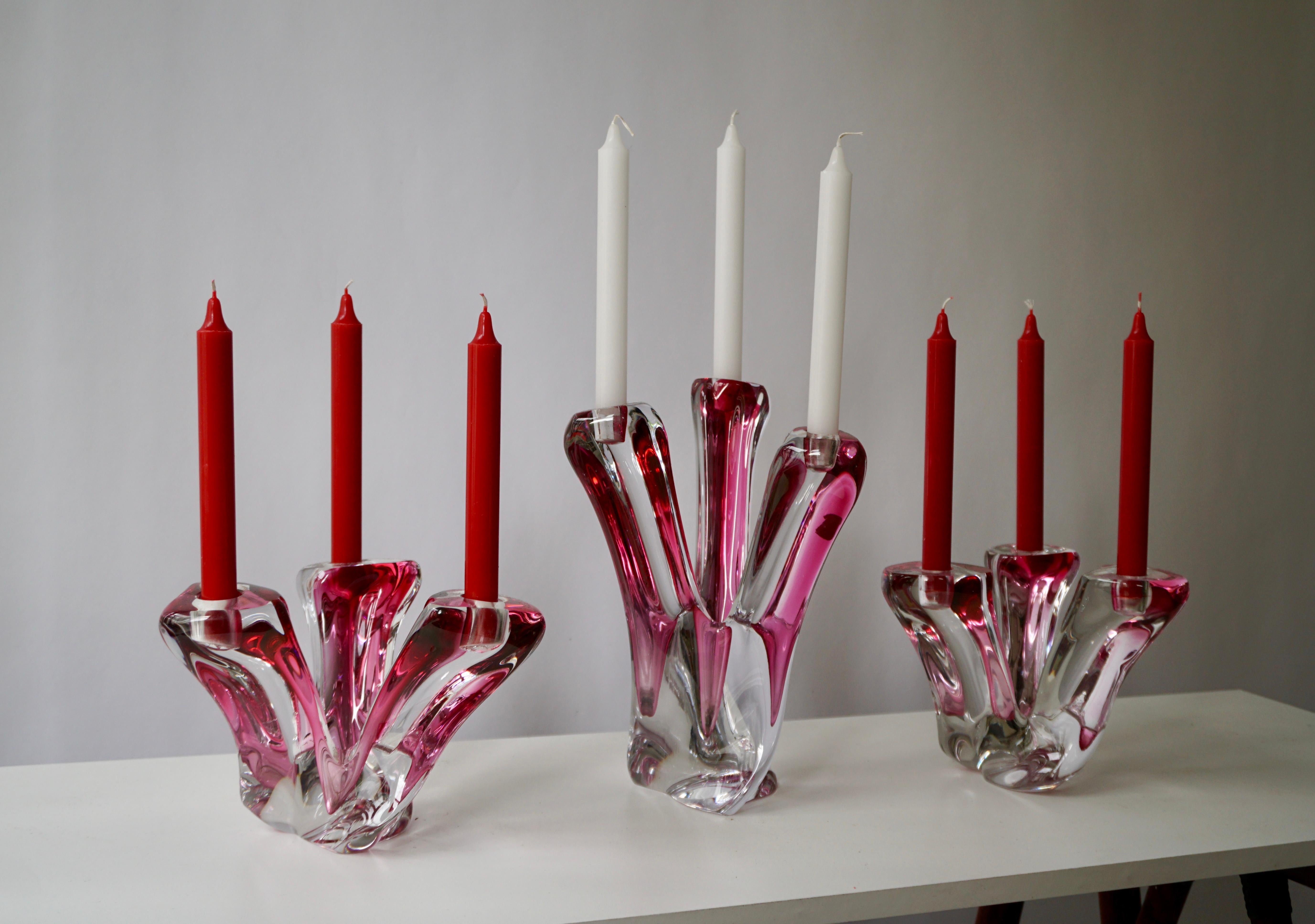 Four of hand blown, clear cut crystal candlesticks with purple and red colored to the centre by Val Saint Lambert, a prestigious Belgium glassware producer established in 1826. Three-armed design with pedestal base. Signed Val Saint Lambert