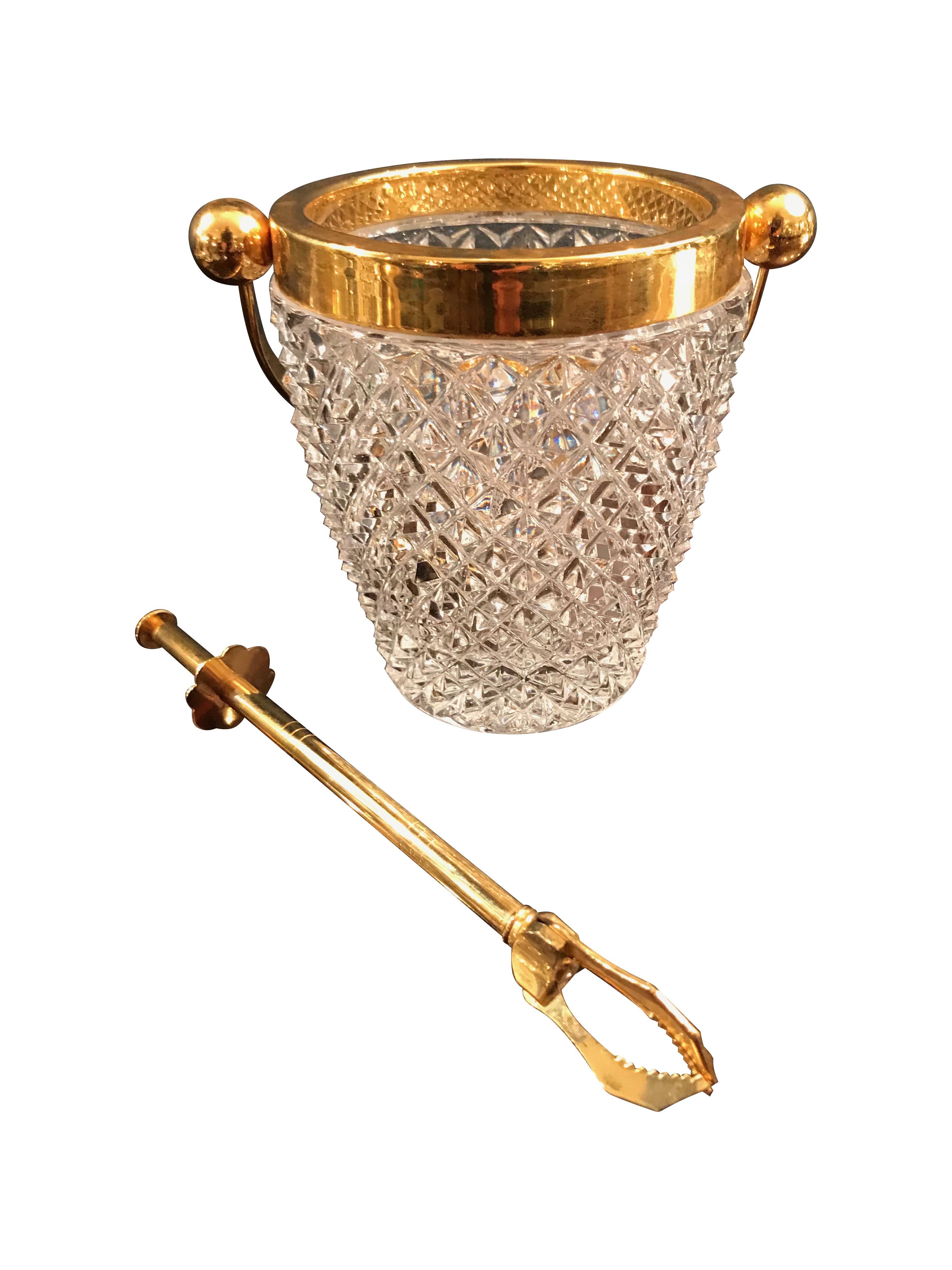 A Val St Lambert crystal ice bucket with gold plated rim and handle, with gilt metal ice grabber.