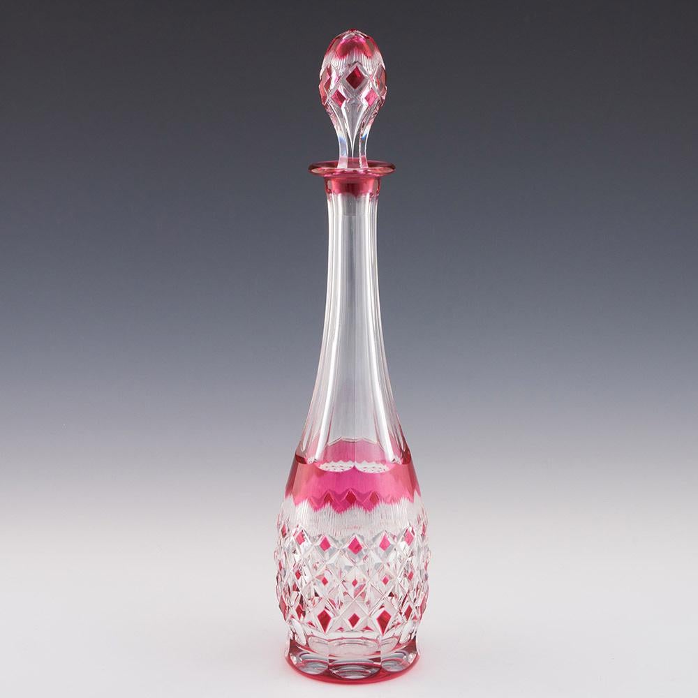 Heading : Val St Lambert decanter c1935
Date : c1935
Origin : Belgium
Colour : Cranberry cut to clear
Stopper : Hollow
Neck : Tapered slice cut
Body : Band of blaze cutting avoce large cranberry tipped diamonds.
Base : Polished – Signed Val St