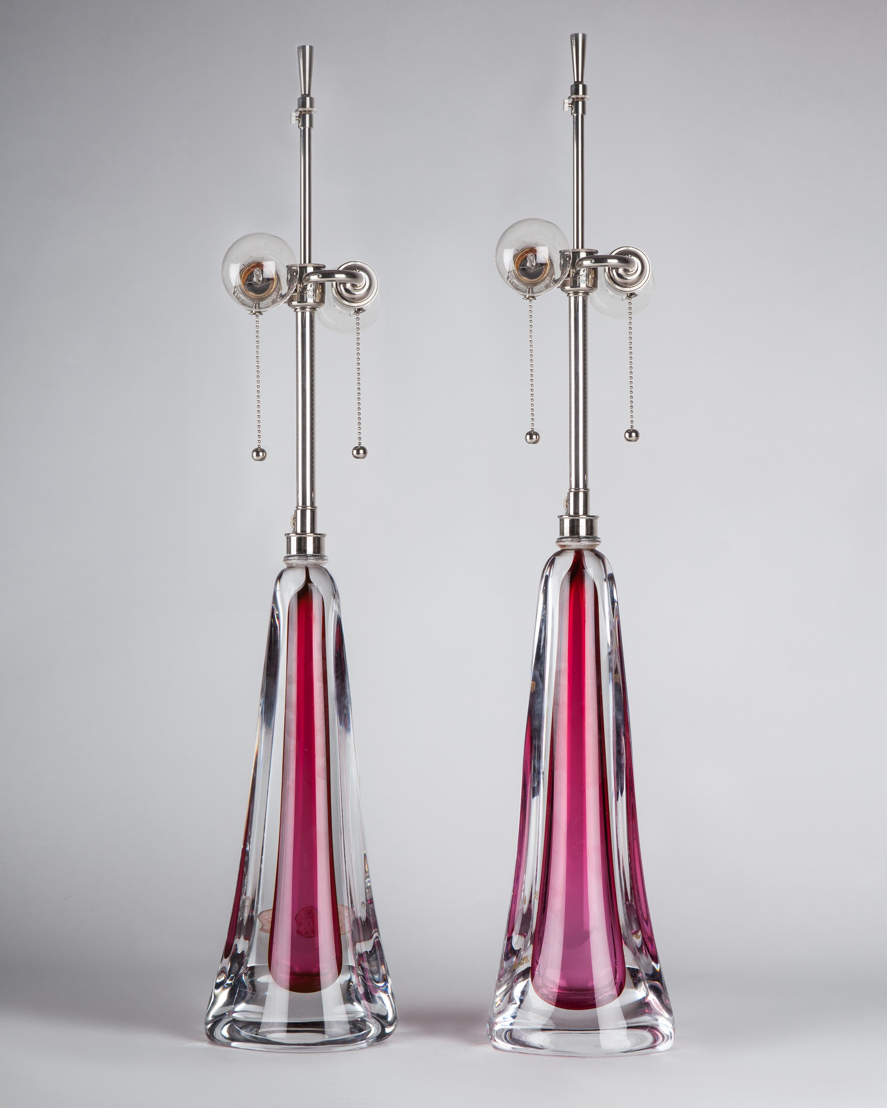 ATL1957
A pair of vintage lamps with handblown cased ruby glass bases with polished nickel fittings. Signed by the Belgian maker Val St. Lambert. Due to the antique nature of these fixtures there may be nicks and imperfections in the glass as well