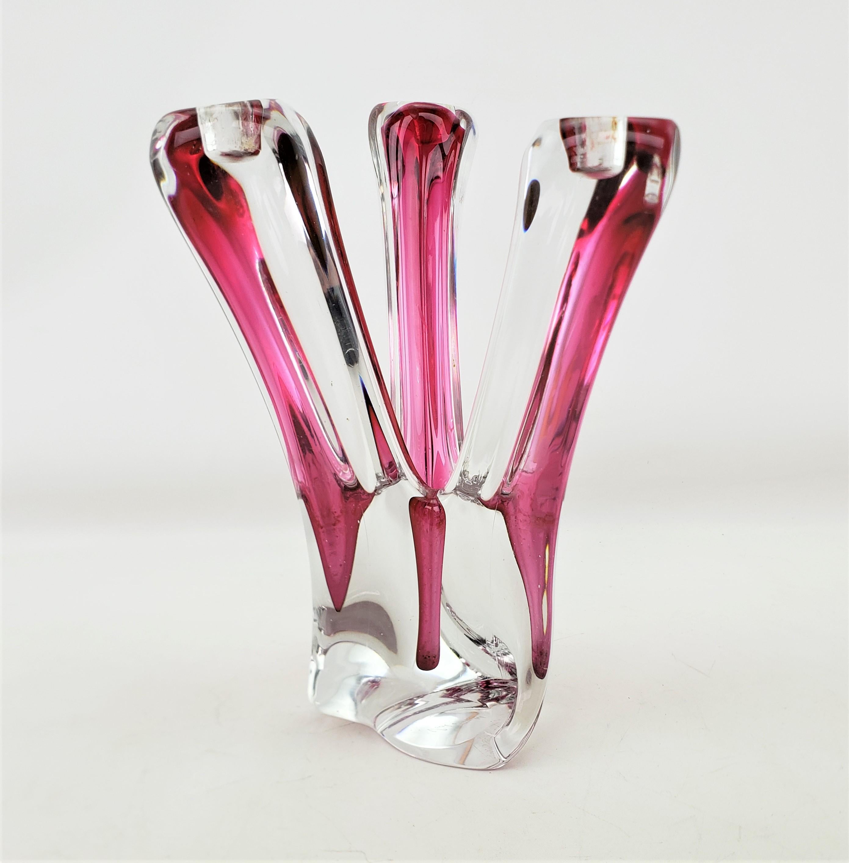 Questo grande e sostanzioso candelabro a tre bracci è stato realizzato dalla rinomata fabbrica belga Val Saint Lambert nel 1950 circa, in stile Mid-Century Modern. Questo portacandele è composto da un pesante cristallo trasparente con inclusioni di