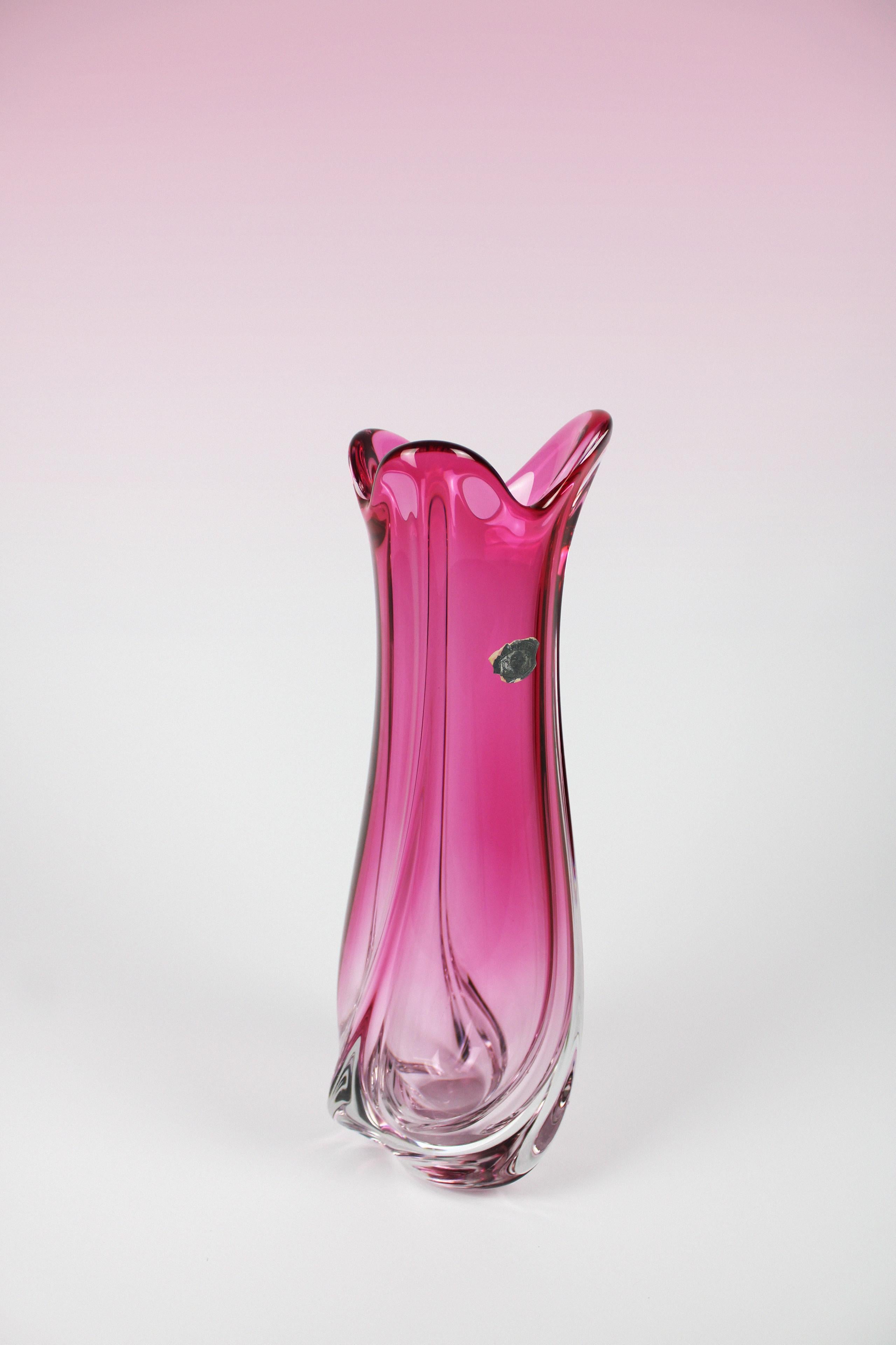 This crystal vase by Val St. Lambert, a Belgian manufacture known for their glassware, is a special piece to have in your home. It is a large vase with an organic shape and immediately stands out with its pink color. It is an original piece that is
