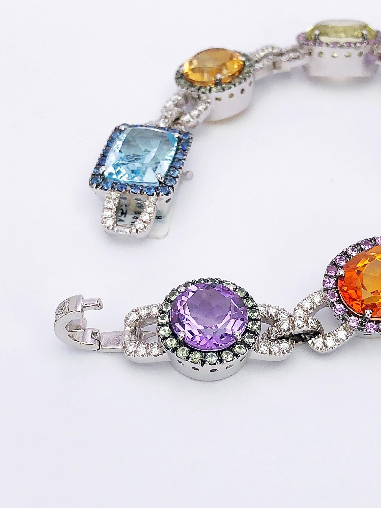 This bracelet is composed of 48.76 carats of semi-precious gemstones. The beautiful array of stones is outlined with 3.93 carats of sapphires and linked with 2.08 carats of pavé diamonds. Set in 18-karat white gold. The bracelet measures 8