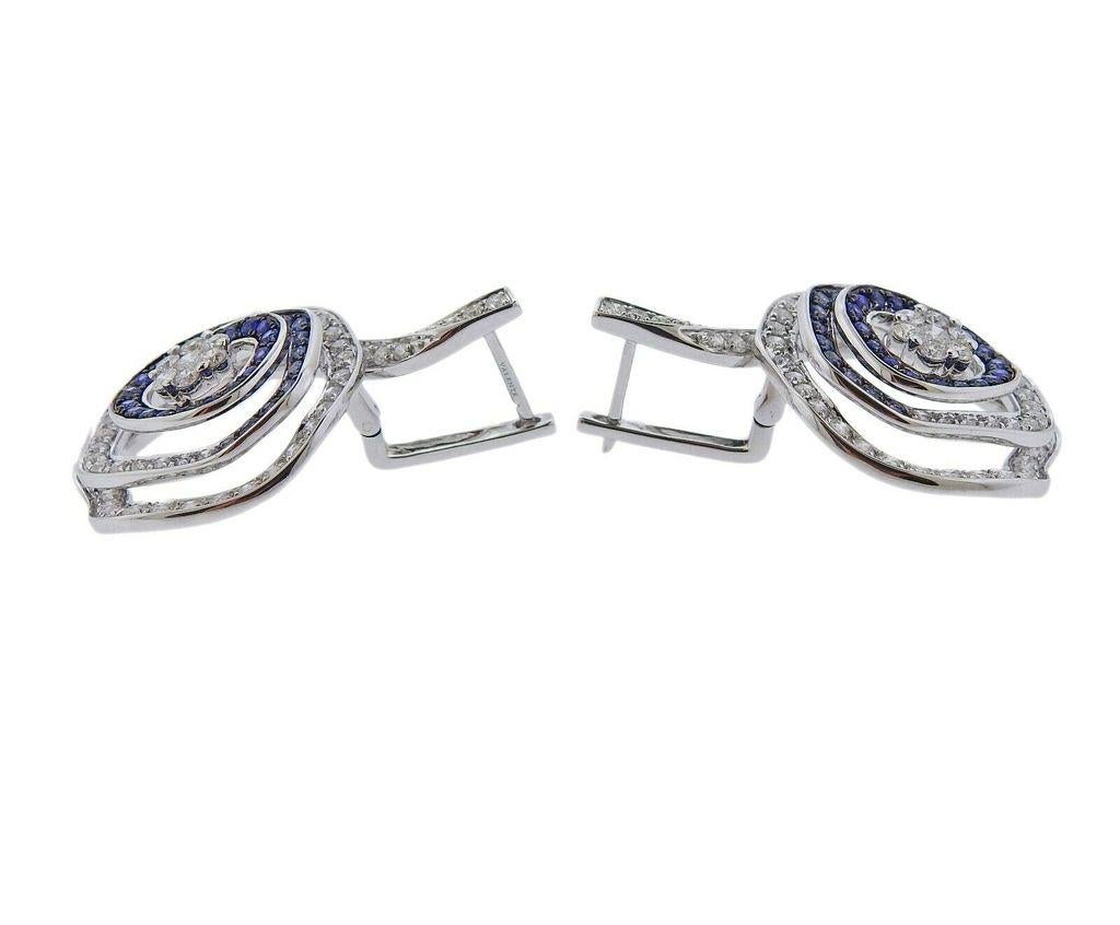 Pair of 18k gold Valente earrings, adorned with 2.17ctw in G/VS diamonds and 0.94ctw in blue sapphire.
~ Brand new, Store sample. Tags removed for photographing ~
Earrings are 33mm long x 22mm at widest point. Weight is 14.3 grams. Marked Valente,