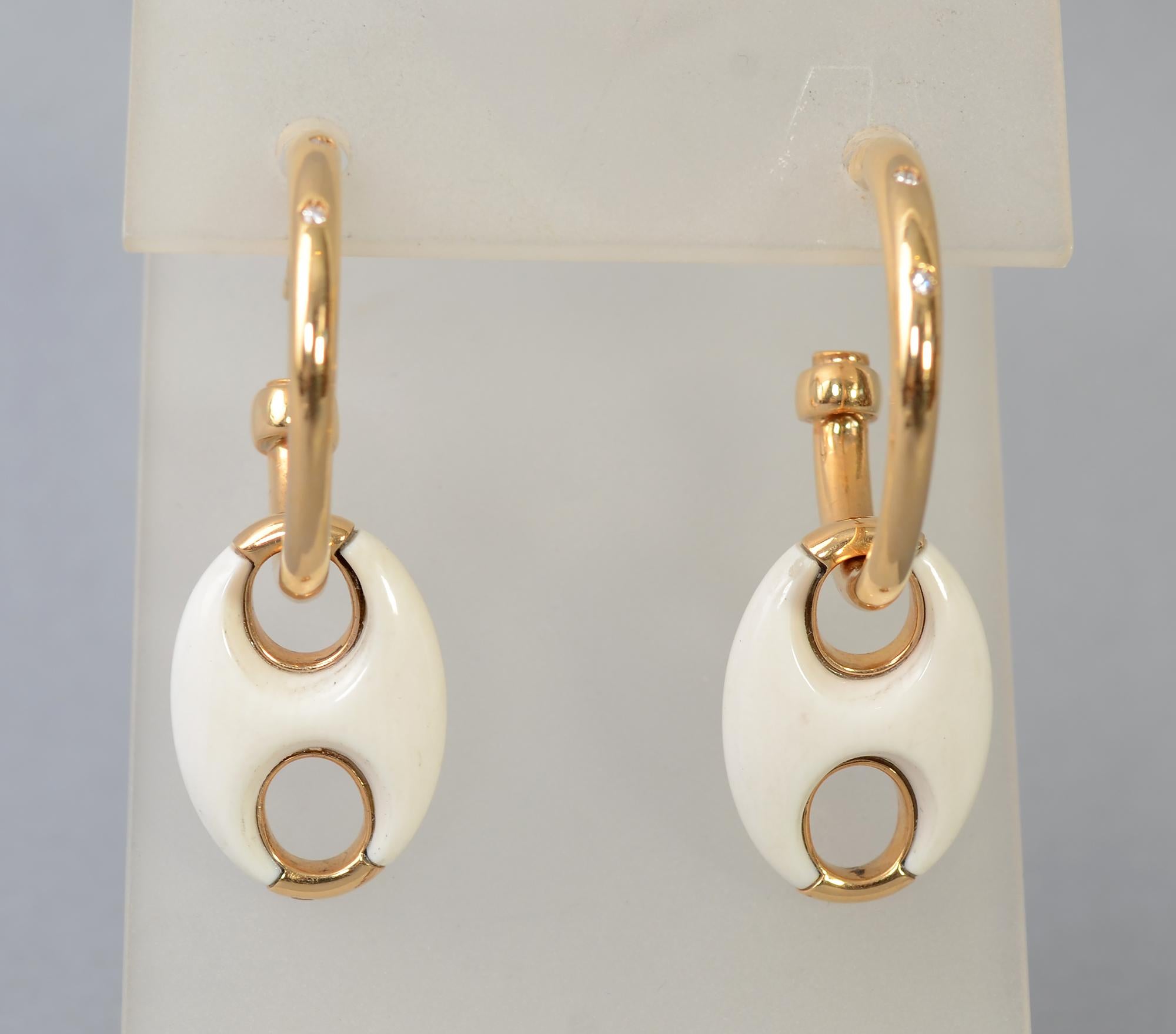 These Valente earrings are beautiful; unusual and versatile. The gold hoops are 1 inch in diameter. Each has three diamonds. A removable oval pendant of white onyx is embellished with orange sapphires.  It can be worn with the sapphires showing or