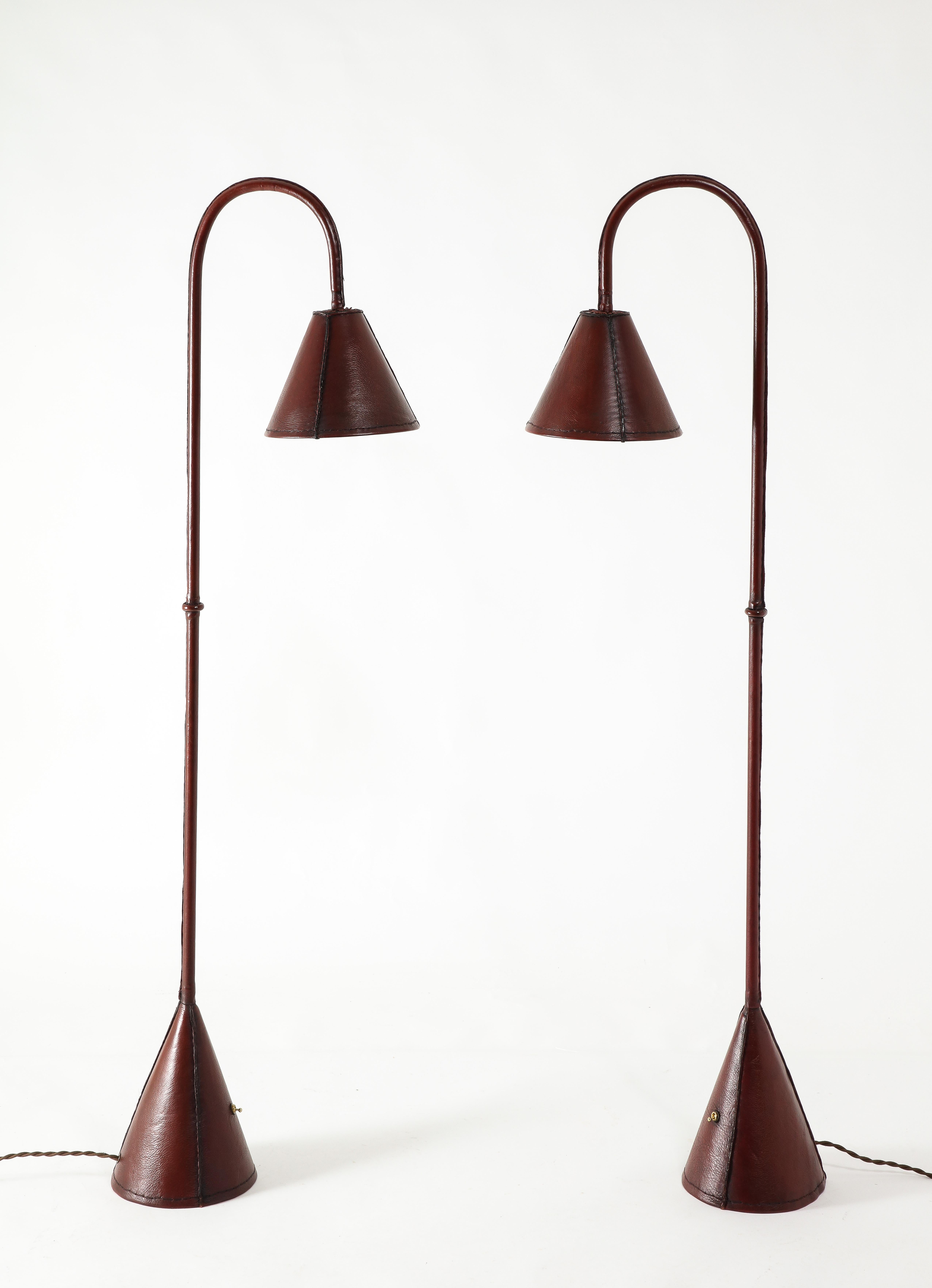 Pair of hand-stitched reading lamps in a rich deep burgundy leather. Great condition and rare as a pair.
