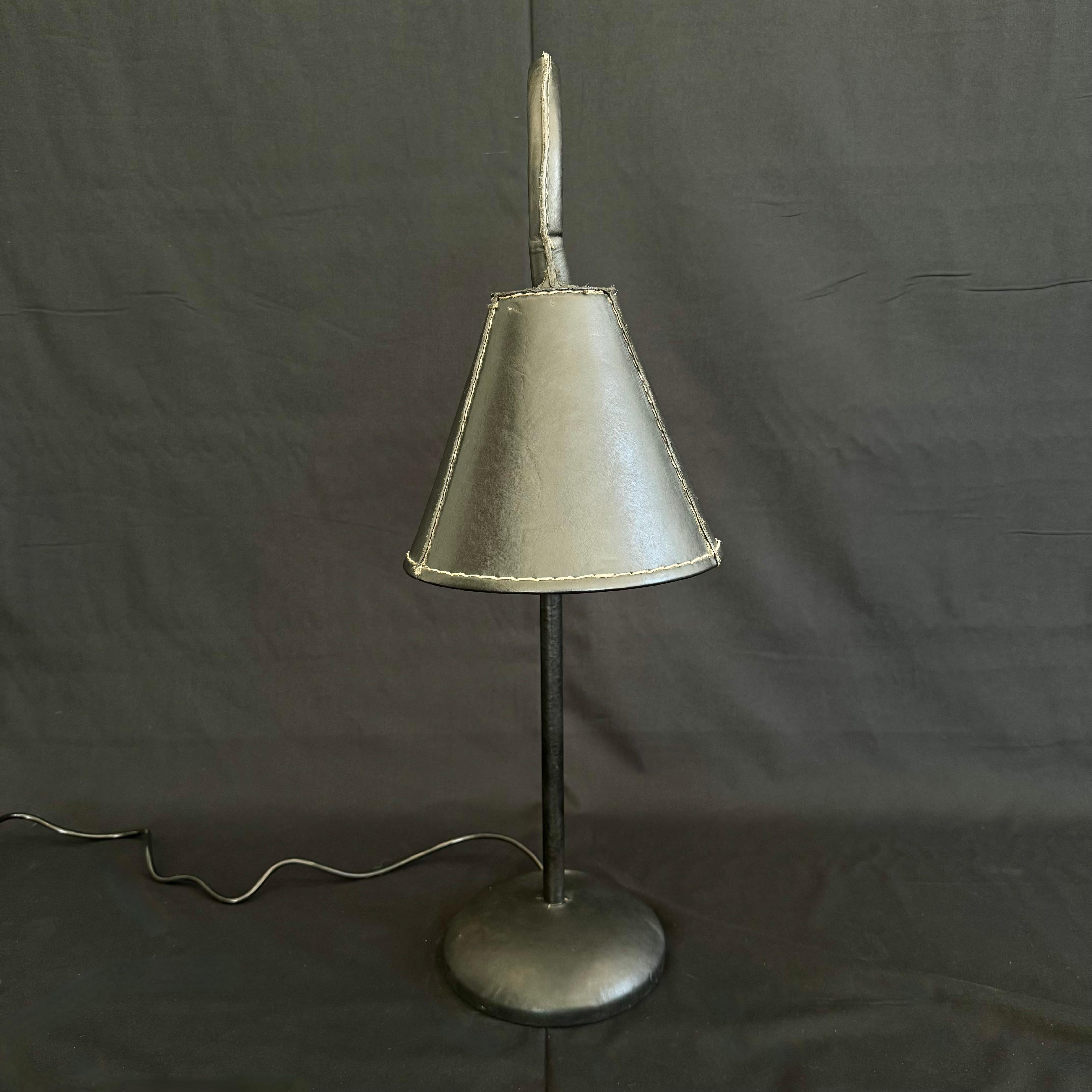 Handsome leather arched table lamp by Spanish design house, Valenti. Based in Barcelona and founded over 200 years ago, Valenti has deep roots in high end furniture and elegant designs. Made in the 1970s this table lamp is completely wrapped in an