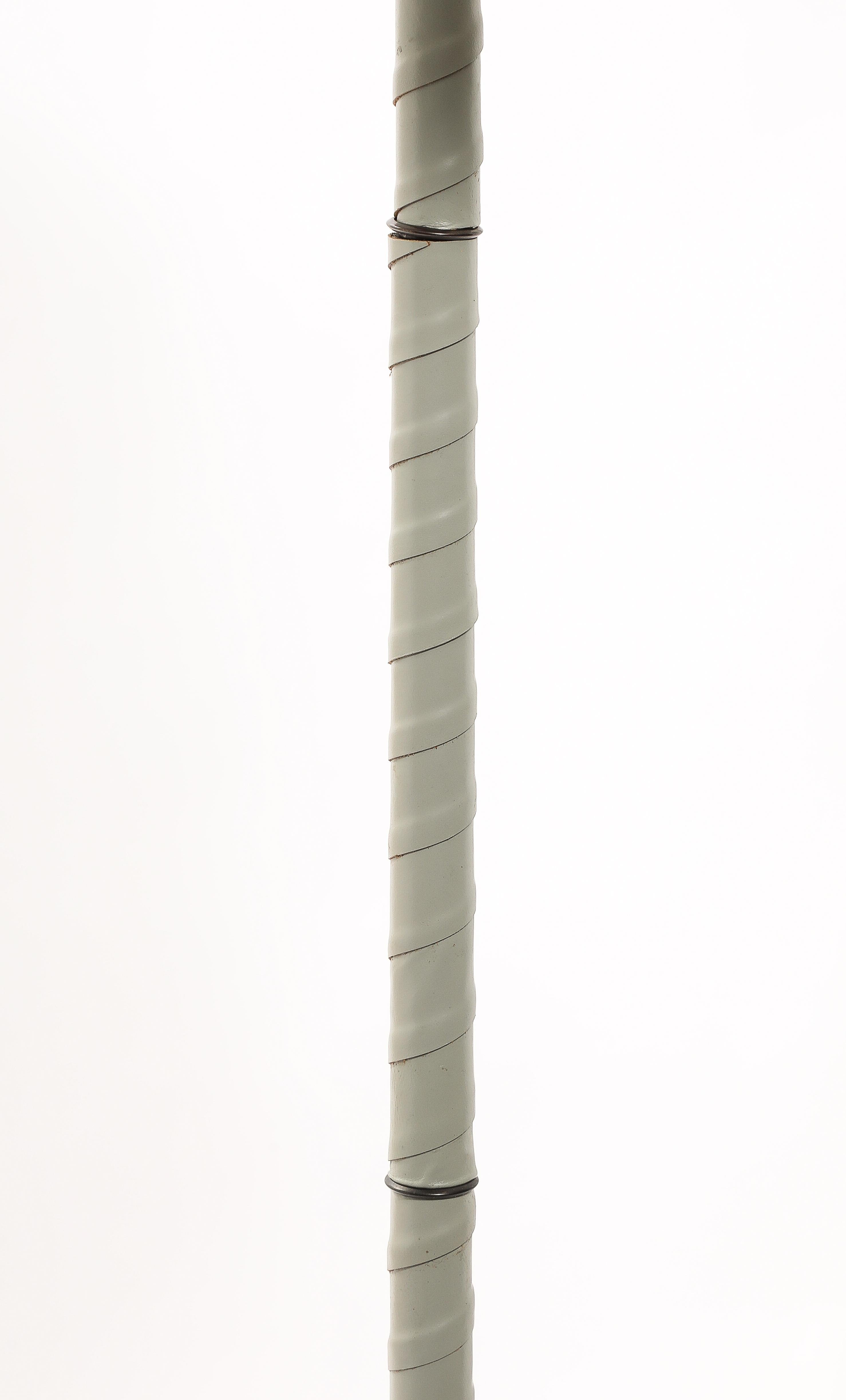 Twist leather-wrapped floor lamps on iron and brass bases.
