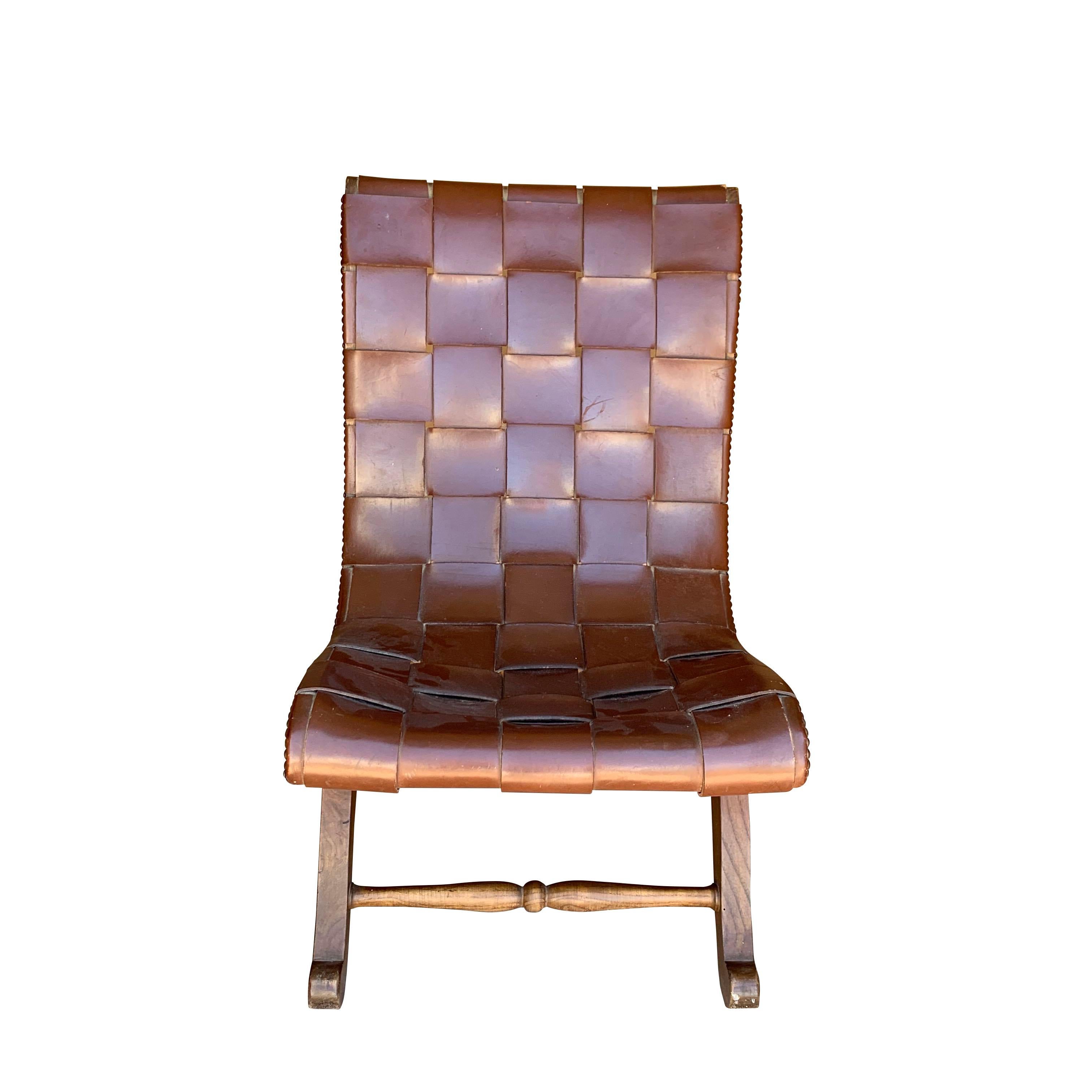 Spanish designer Valenti brown woven leather side chair with a trademark designed wood base.
Seen from the side are sculptural clean lines and curved legs with the nailhead trim following the lines of the chair.
The woven leather is seamless,