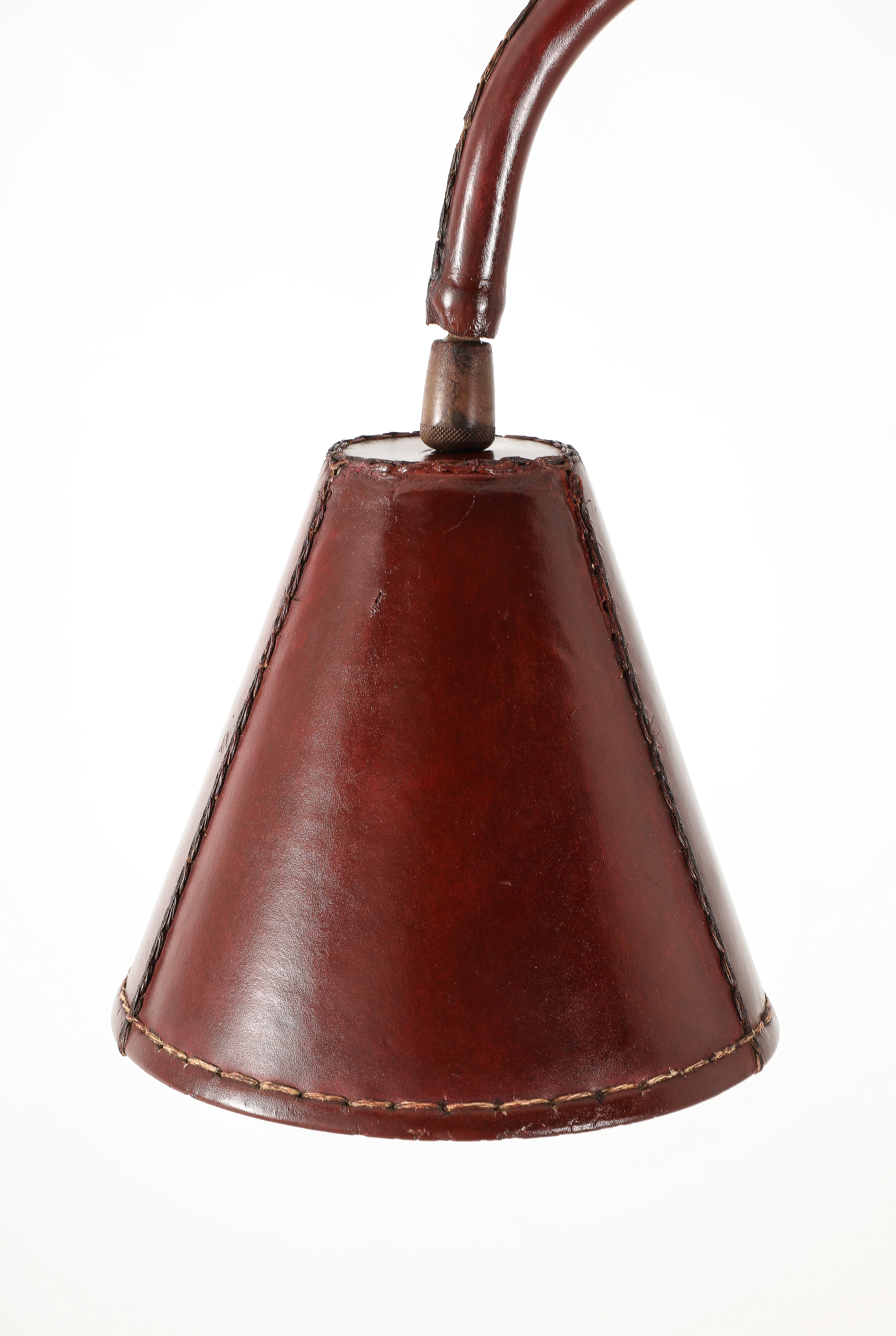 A Stitched leather covered desk lamp by Valenti, steel construction with brass swivel.
