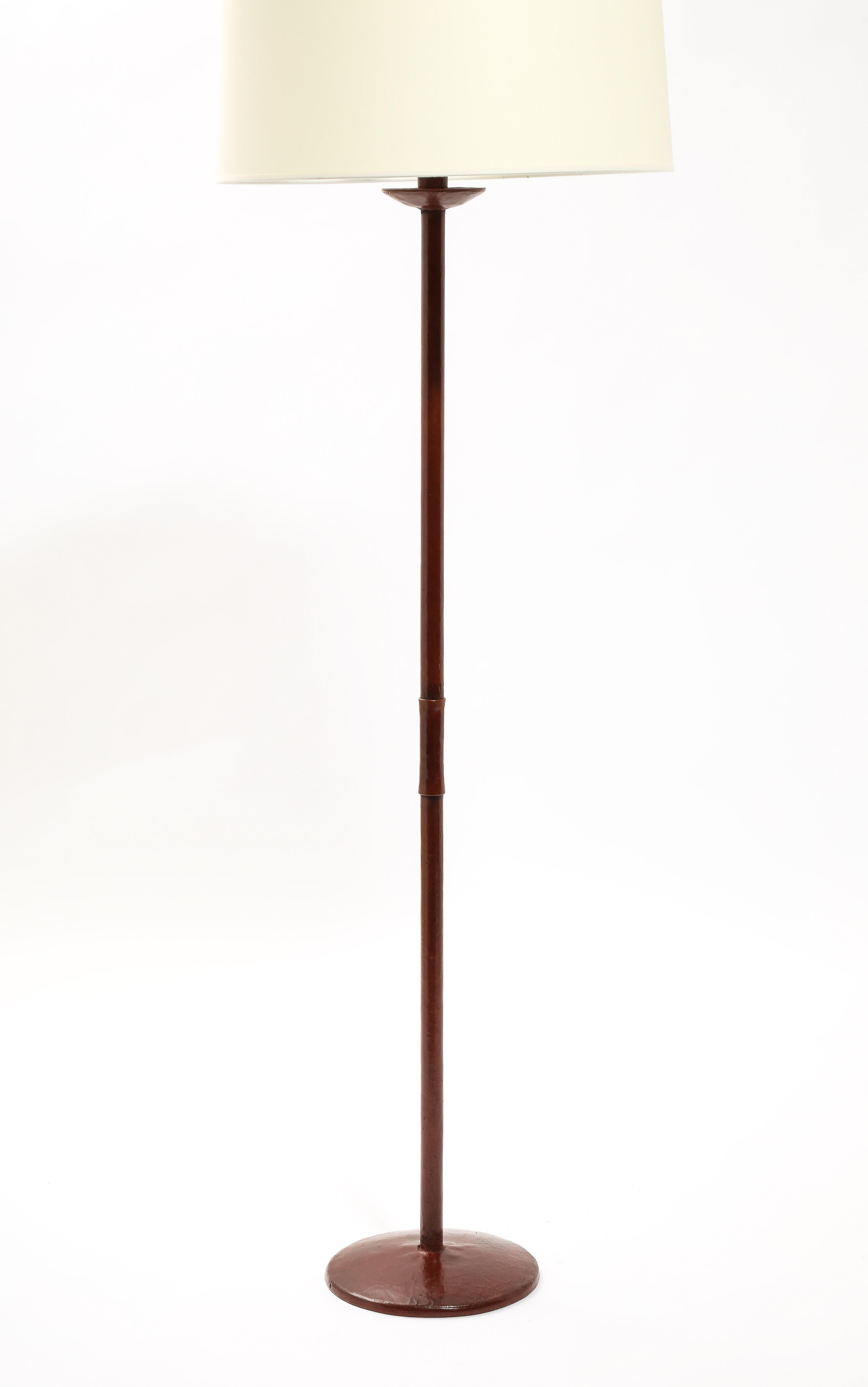 Lampada da terra rivestita in pelle bordeaux di Valenti od Spain con un dettaglio a punto baseball sullo stelo. Solo la base 63x10.
