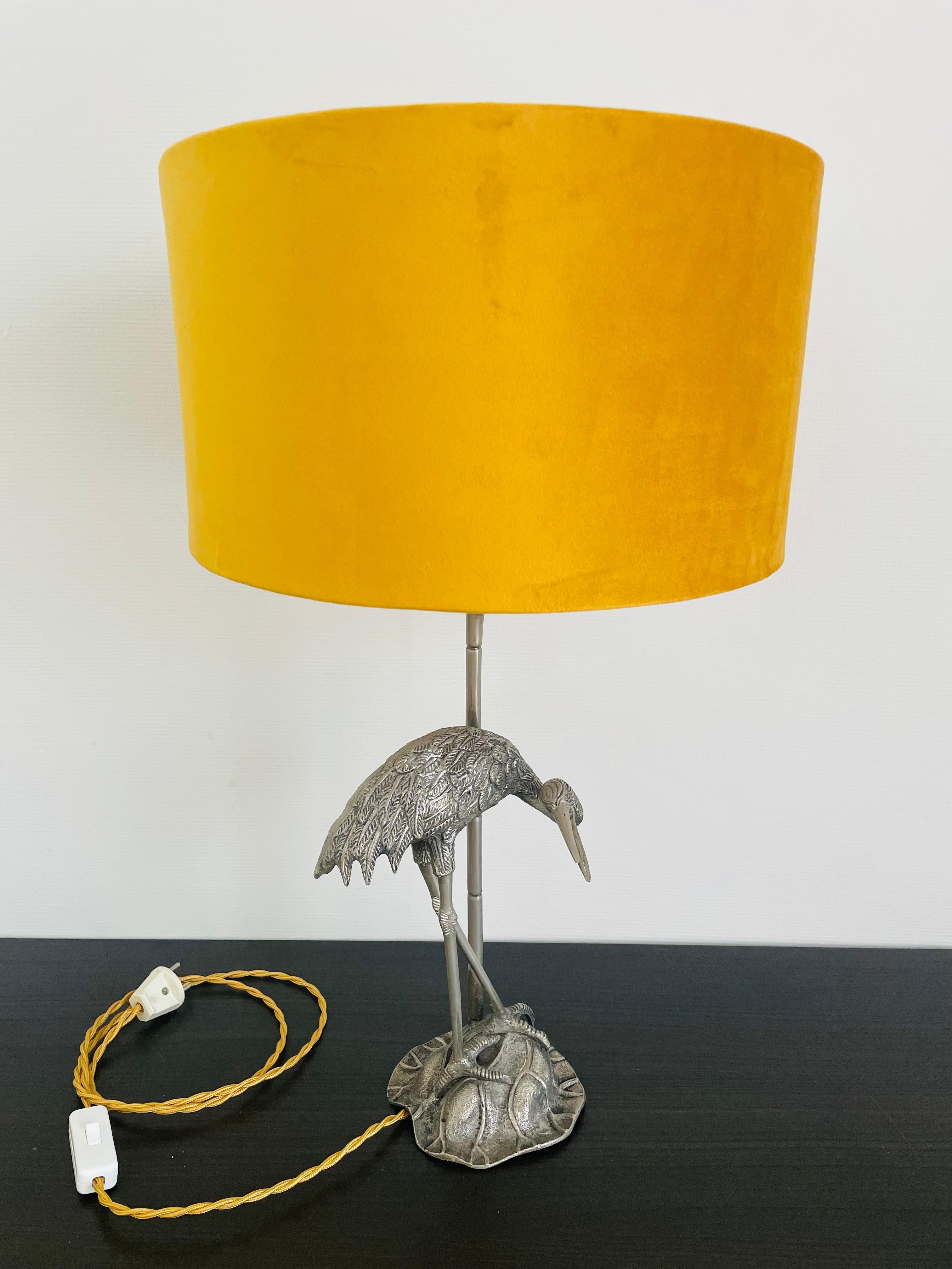 Beautiful crane bird or héron table lamp by Valenti.

Beautifully detailed silver plated crane bird sculpture with a faux bamboo metal rod supporting the lamp and light shade.

Yellow velvet lamp shade creating a warm light. 

Tested and ready