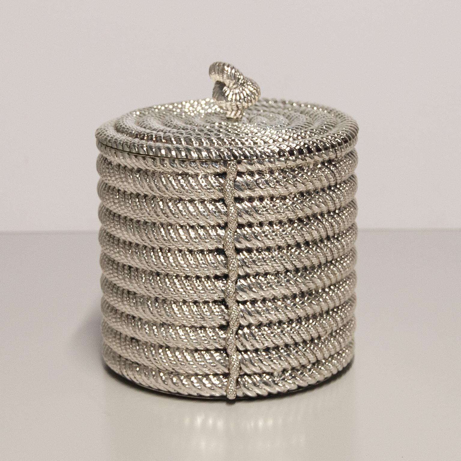 A stylish silver plated ice bucket of cylindrical design in the form of coiled rope with matching lid, by Spanish maker Valenti; circa 1975. The inside liner is insulated to help keep things cool and the inlay is aluminium.
Excellent condition