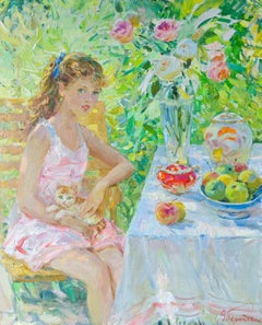 Portrait d'une jeune fille tenant un chaton, assise dans un jardin d'été 1