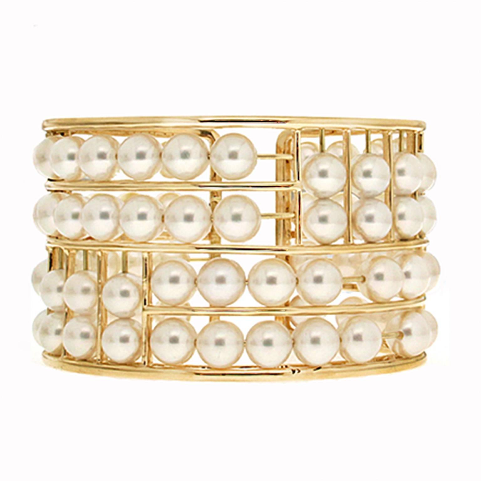 Pearls provide a lustrous complement to this bracelet. 18k yellow gold forms the cuff, which has varying openwork rows. Akoya pearls are strung on gold wires in these rows, giving the impression to be floating. The total weight of the pearls is 76