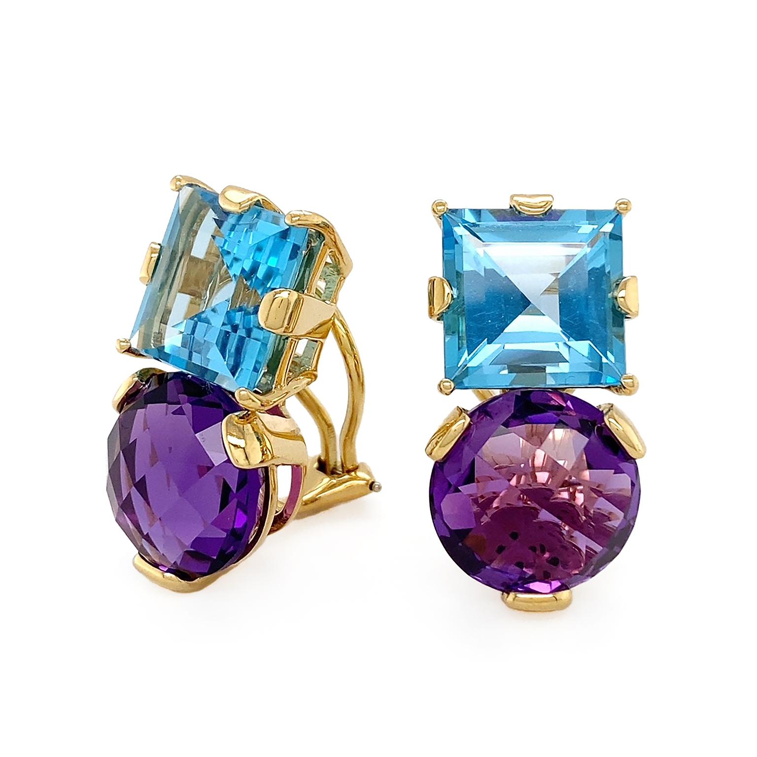 Complementary hued jewels coruscate. A square cut of flickering blue topaz begins the earrings. Beneath is a round checkerboard cut of amethyst, lifting deep plum shades. 18k yellow gold secures the gems. The total weight is 18.19 carats of blue