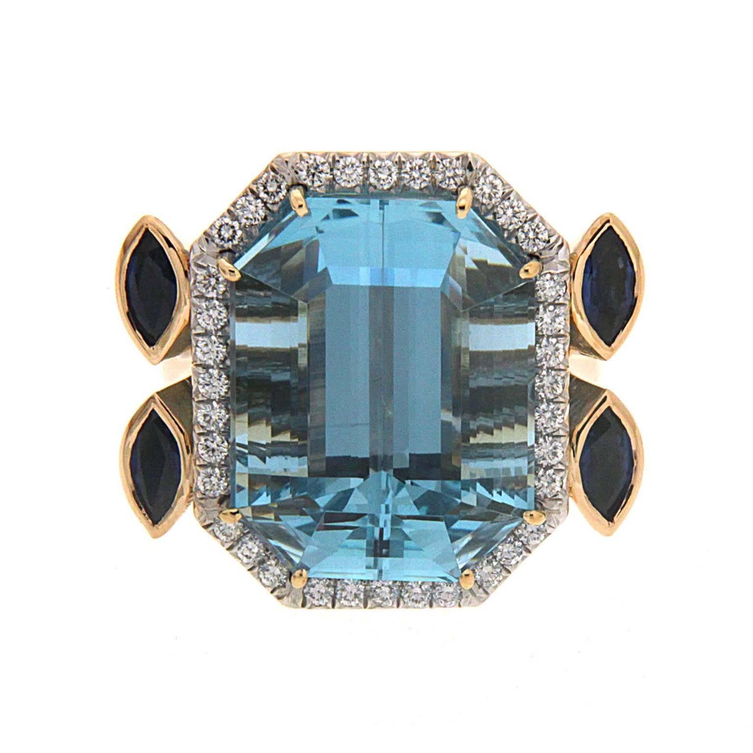 Blue highlights this ring created by Valentin Magro. Its showpiece jewel is an emerald cut aquamarine bordered with pave set round brilliant cut diamonds. Pear shaped aquamarines appear beneath the diamonds. Double bands tipped with marquise shaped