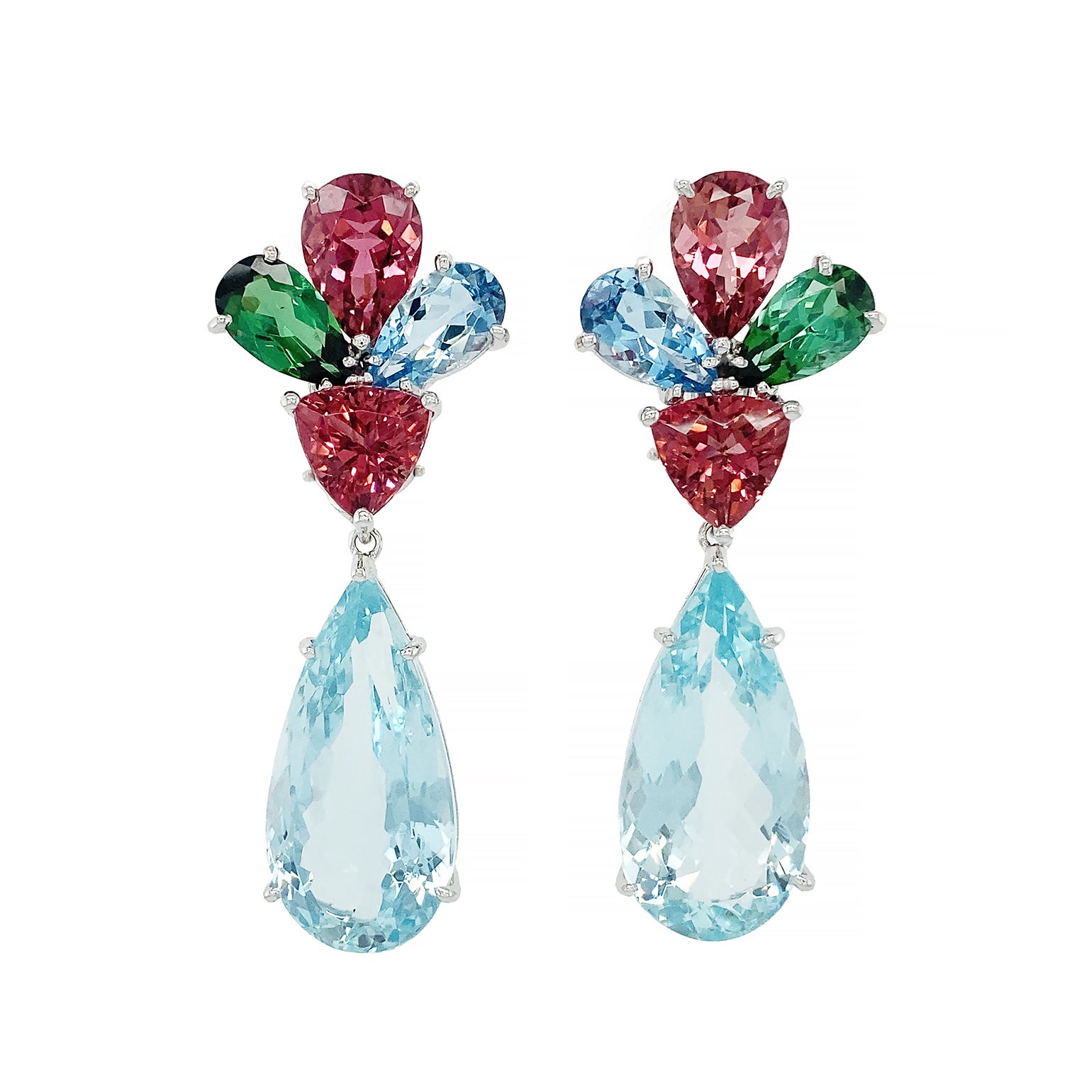 Jewels in primary colors create a vivacious trio. The design begins with three pear shaped cuts of rubellite, green tourmaline and aquamarine. Their broadest ends face outward as their points lead the eye to a trilliant cut of fiery rubellite.