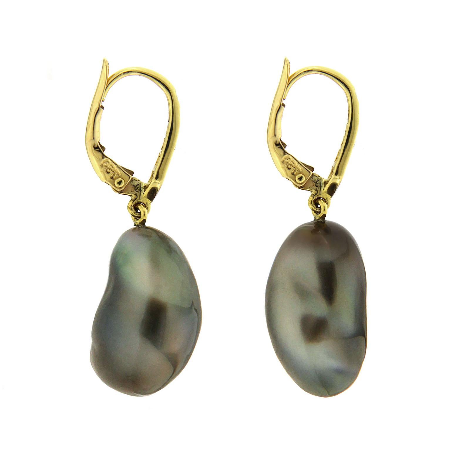 Valentin Magro Baroque Tahitian Pearl Tear Drop Diamond Earrings exhibit strong gleam. Their dark body color makes white light reflections all the more prominent. Additional light scatters along the baroque pearls’ surfaces, creating purple and blue