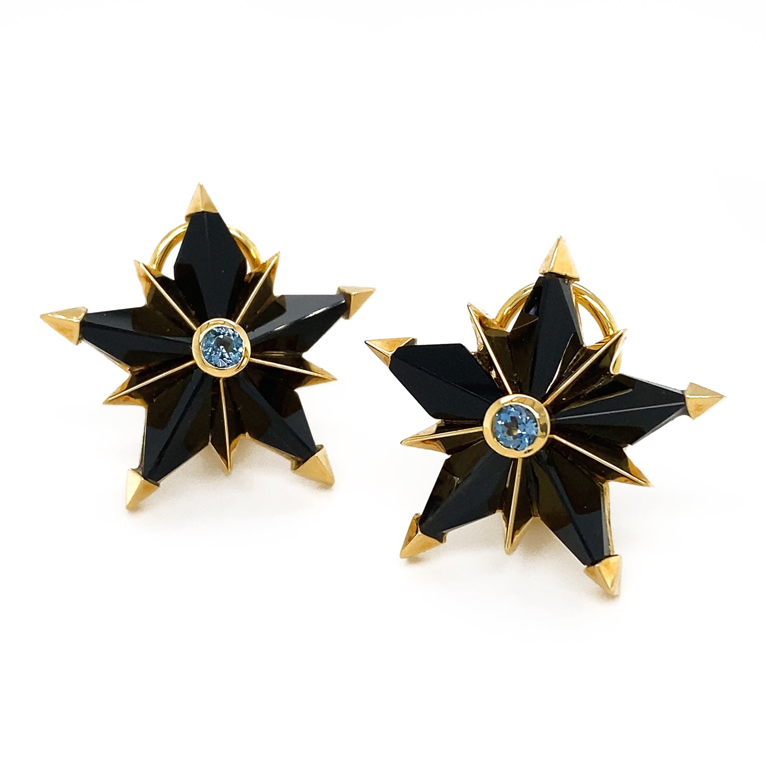 Black jade is the gem of choice cut in a star shape for a bold statement. 18k yellow gold accents the tips of each of the five points, as well as in the center for another five pointed star. In the center is the gleam of an aquamarine for a touch of