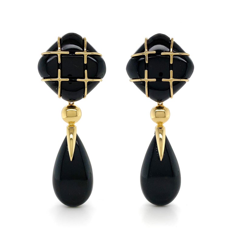 The intensity of black jade is enhanced by the brilliance of 18k yellow gold for these drop earrings. Beginning with a cushion carving of black jade turned on its side, sleek gold bars overlap to form the illusion of a checkered pattern. Next a